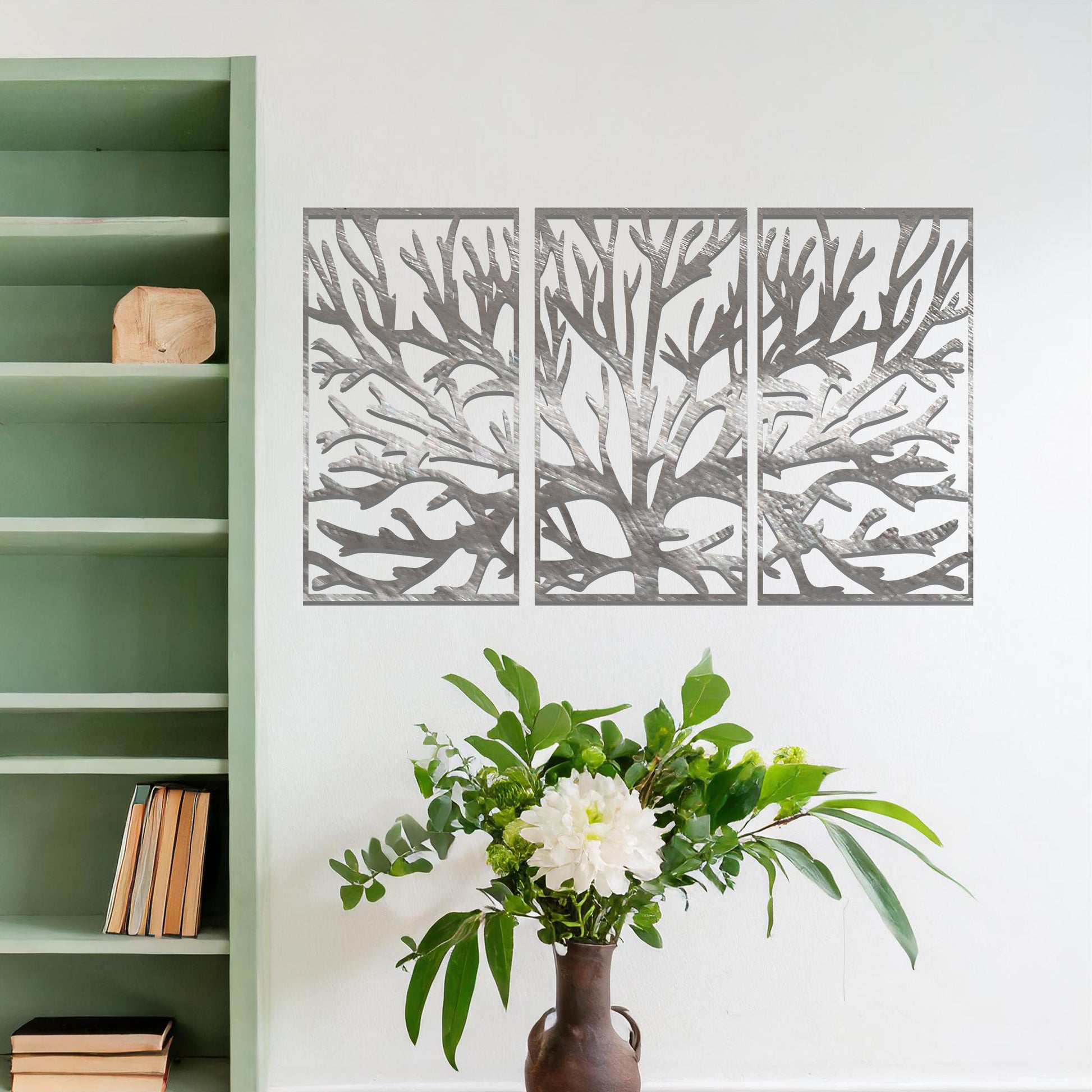 Metal wall art design featuring a stylized tree with intricate branches, presented in a triptych layout. The design captures detailed, organic lines forming the tree’s structure, emphasizing the natural flow and texture of the branches. The art is displayed on a neutral wall.