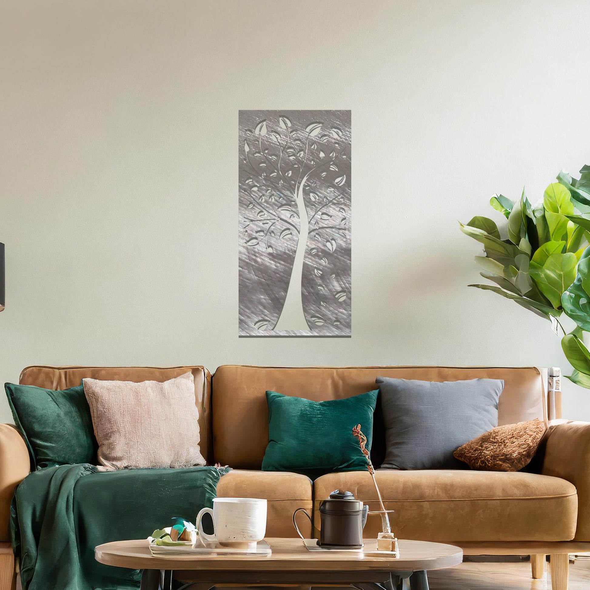 Metal wall art featuring a tree with intricate branches and leaves, enclosed in a vertical rectangular frame. The artwork is displayed on a neutral wall within a modern office setting, complemented by a desk, chair, and indoor plants.