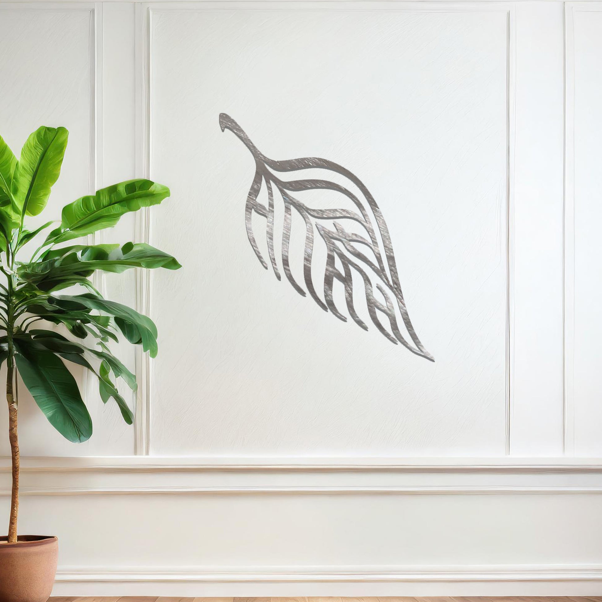 Metal wall art featuring a stylised leaf design with intricate linework and the word "Allah" seamlessly incorporated, mounted on a neutral wall within modern room decor. The elegant craftsmanship and spiritual motif make it a striking focal point in the space.