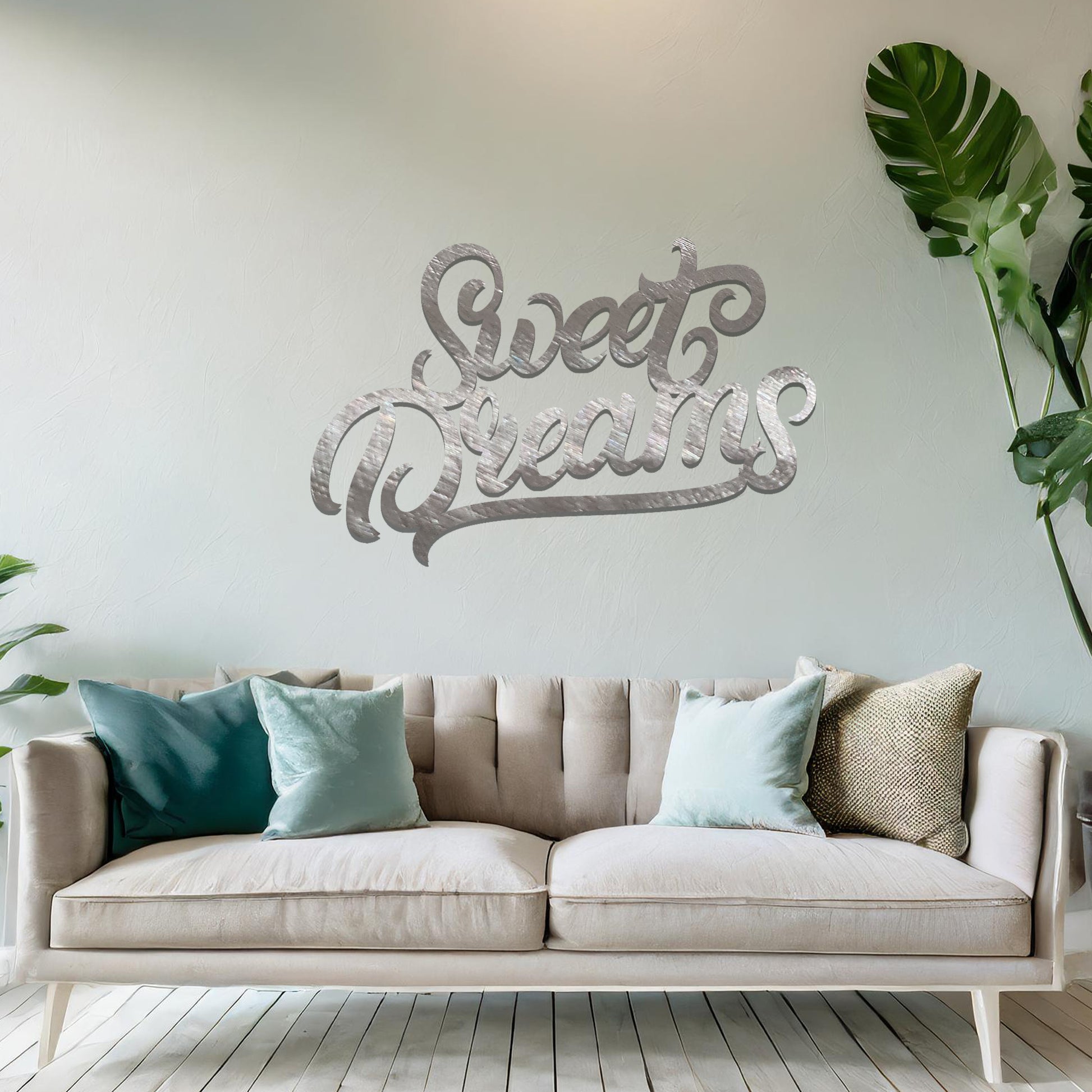 Metal wall art featuring the phrase "Sweet Dreams" in an elegant cursive font, mounted on a neutral wall within modern room decor. The artistic typography adds a charming and comforting focal point, perfect for enhancing the cosy ambiance of the space.