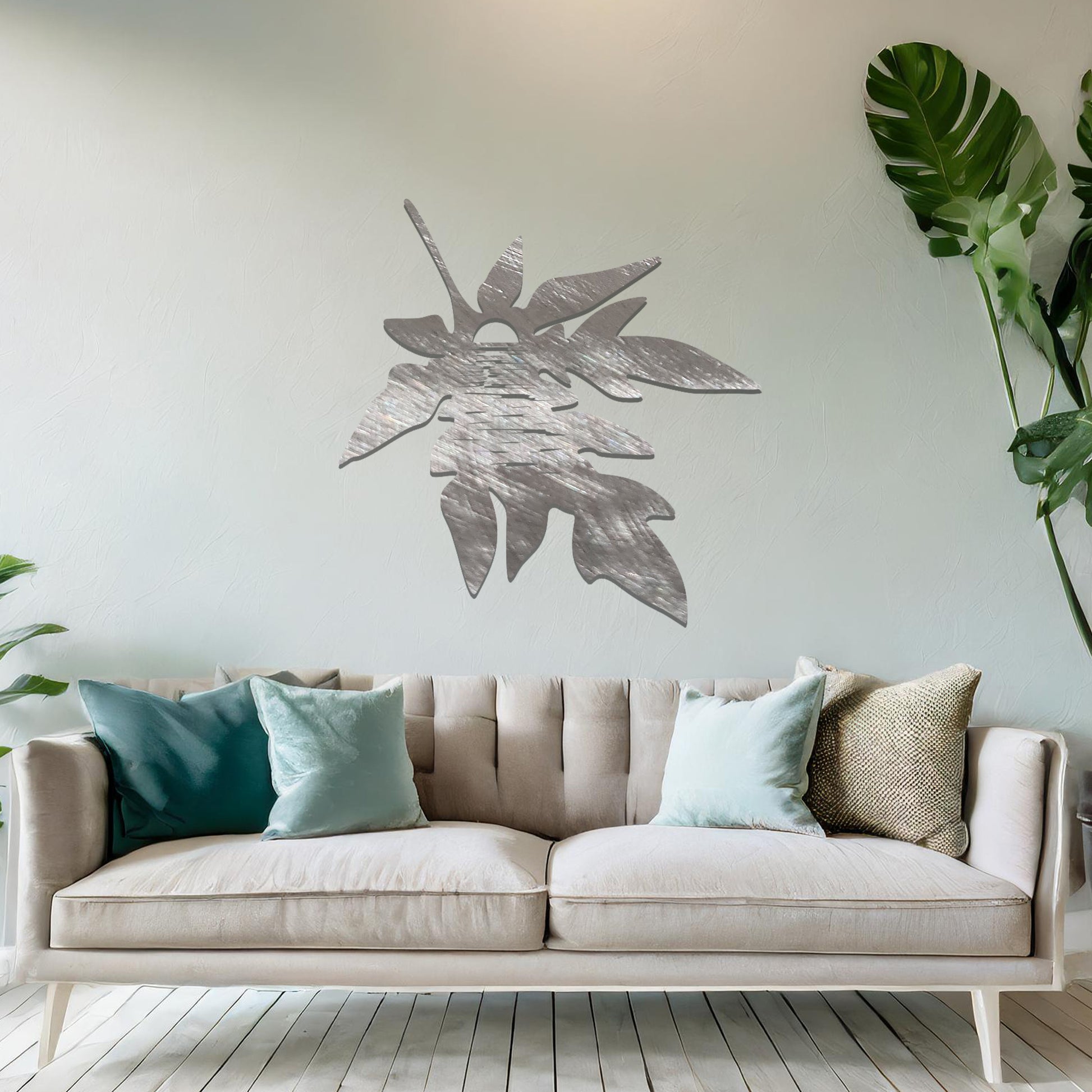 Metal wall art featuring a stylised leaf design with intricate line details, incorporating a circular motif resembling the sun or moon, mounted on a neutral wall. The organic form and minimalist design add a serene and artistic touch to the space.