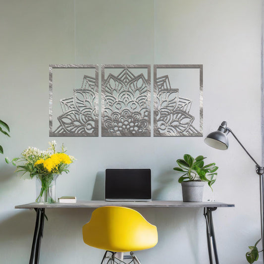 A metal wall art design featuring a detailed mandala pattern, divided into three panels. The intricate floral design is framed within each section. The art is displayed on a neutral wall in a modern bedroom, adding elegance to the peaceful setting.