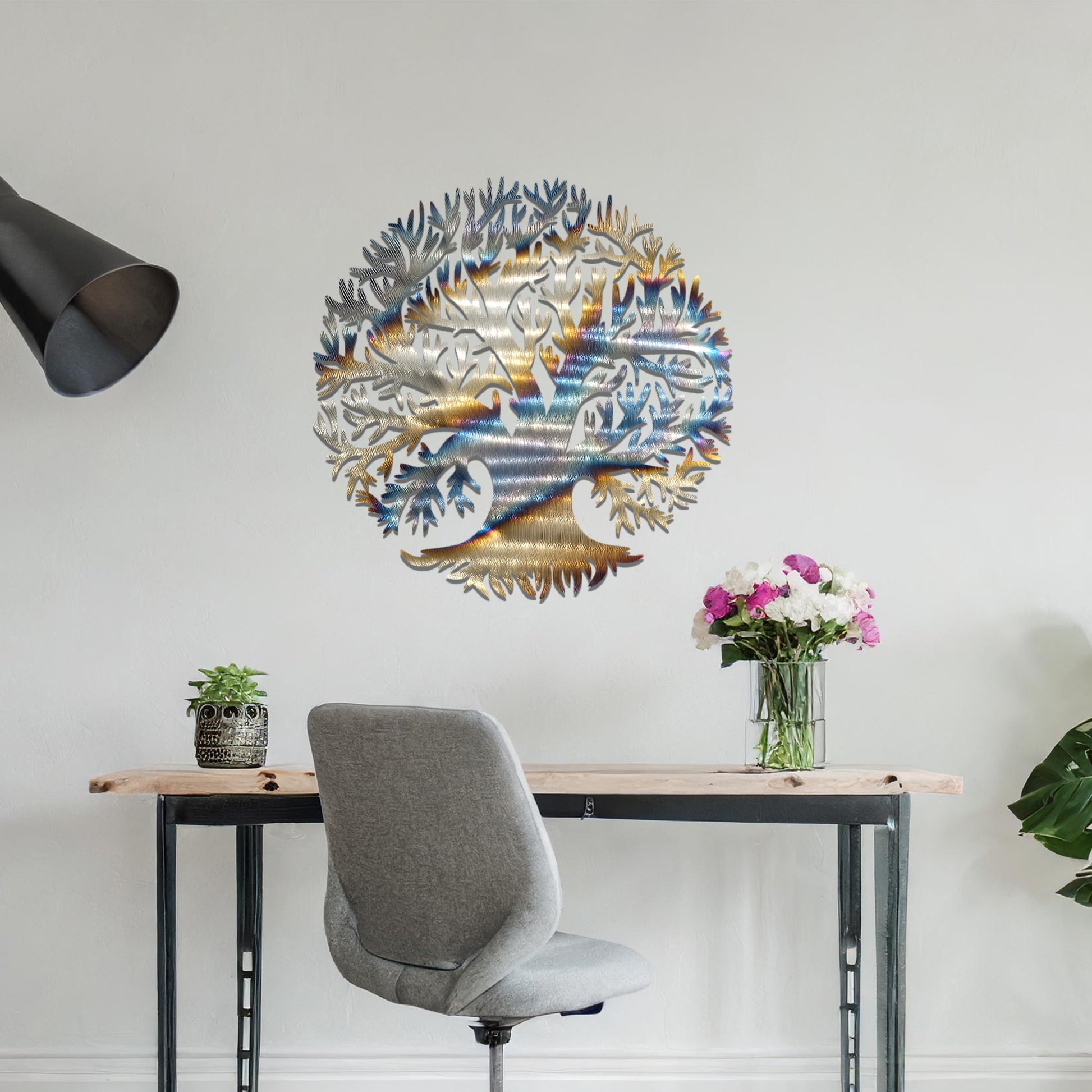 Metal wall art featuring a circular tree design with intricate branches and roots, crafted with precise laser-cut detailing, placed on a neutral wall within modern decor.