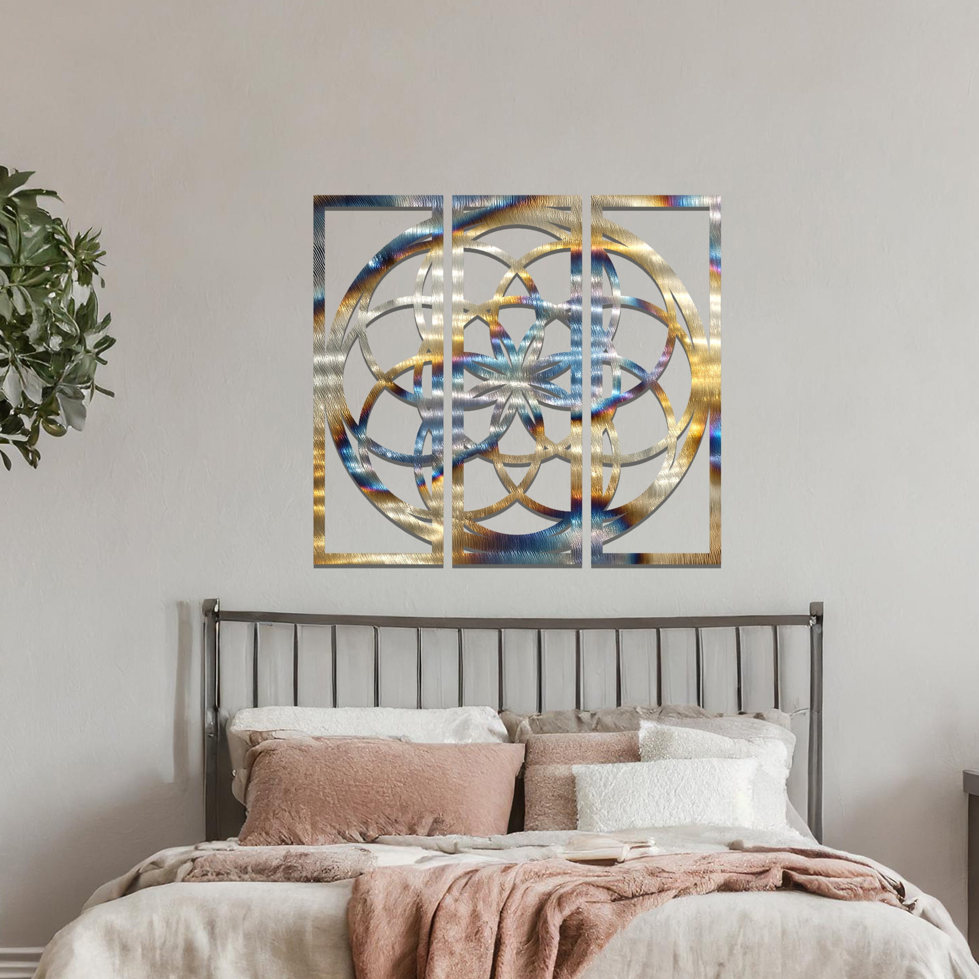 A three-panel metal wall art featuring a geometric floral pattern with interlocking circles and a star-shaped center. The design is displayed on a neutral wall, enhancing the room's modern aesthetic with its elegant symmetry.