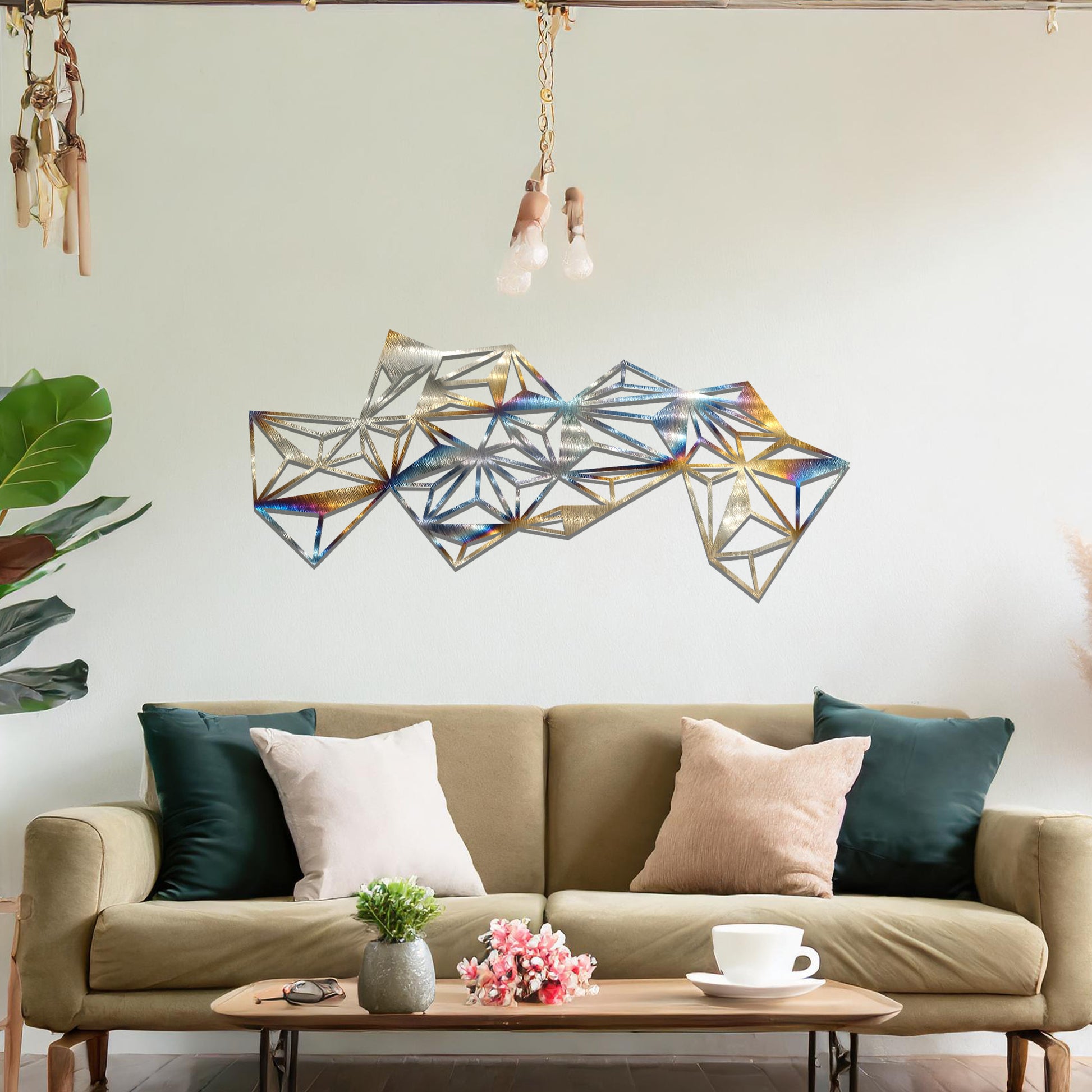 Metal wall art featuring an abstract geometric design with multiple interconnected triangular shapes, creating a dynamic, faceted pattern. The art is placed on a neutral wall within a modern room, complementing the vibrant decor with plants and furniture.