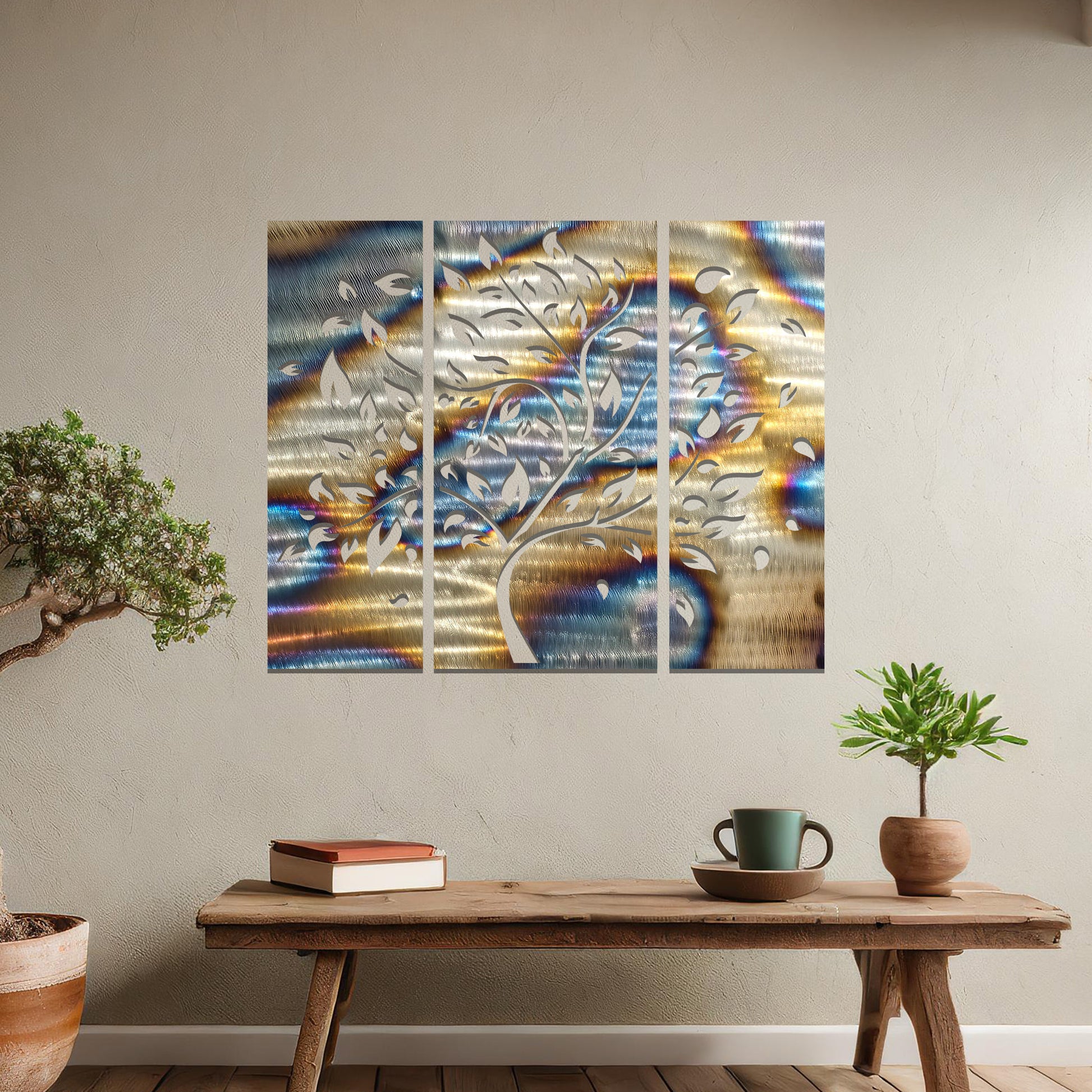Metal wall art featuring a three-panel tree design with curved branches and delicate leaves, crafted with precise laser-cut detailing, displayed on a neutral wall within modern decor.