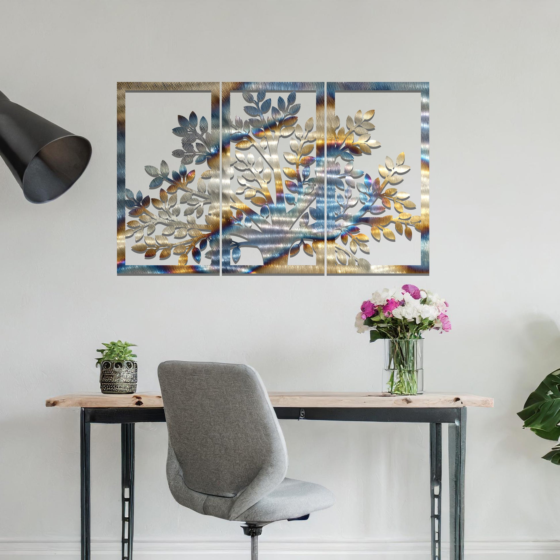 Metal wall art featuring a three-panel tree design with a detailed trunk, branches, and clustered leaves, crafted with precise laser-cut detailing, displayed on a neutral wall within modern decor.