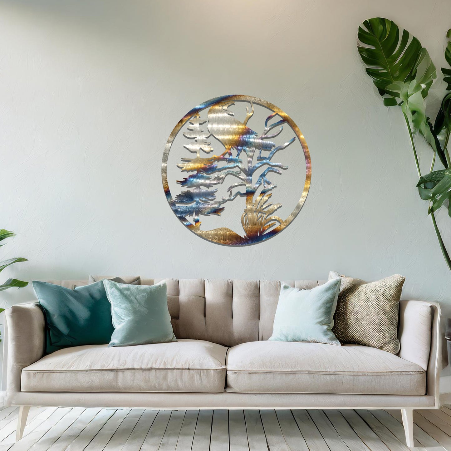 Metal wall art featuring a circular design with a silhouette of a raven perched on a tree branch, surrounded by trees and foliage, mounted on a neutral wall within modern room decor. The intricate detailing and natural motif create a bold and artistic focal point in the space.