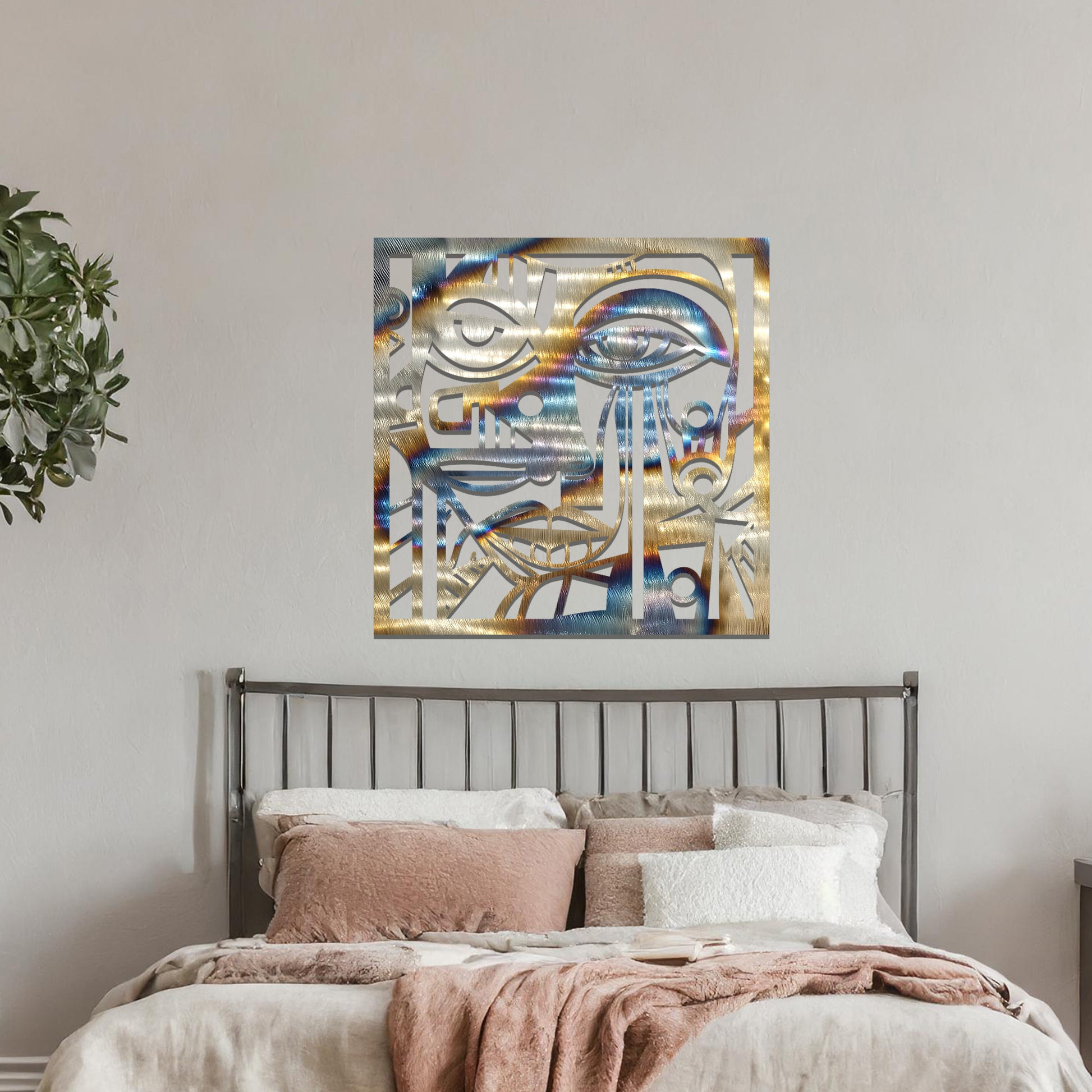A metal wall art design featuring an abstract face with geometric shapes and sharp lines. The face's features are creatively outlined with strong contrasts, adding a modern, artistic touch to the space. The piece is displayed on a neutral wall, enhancing the room’s decor.