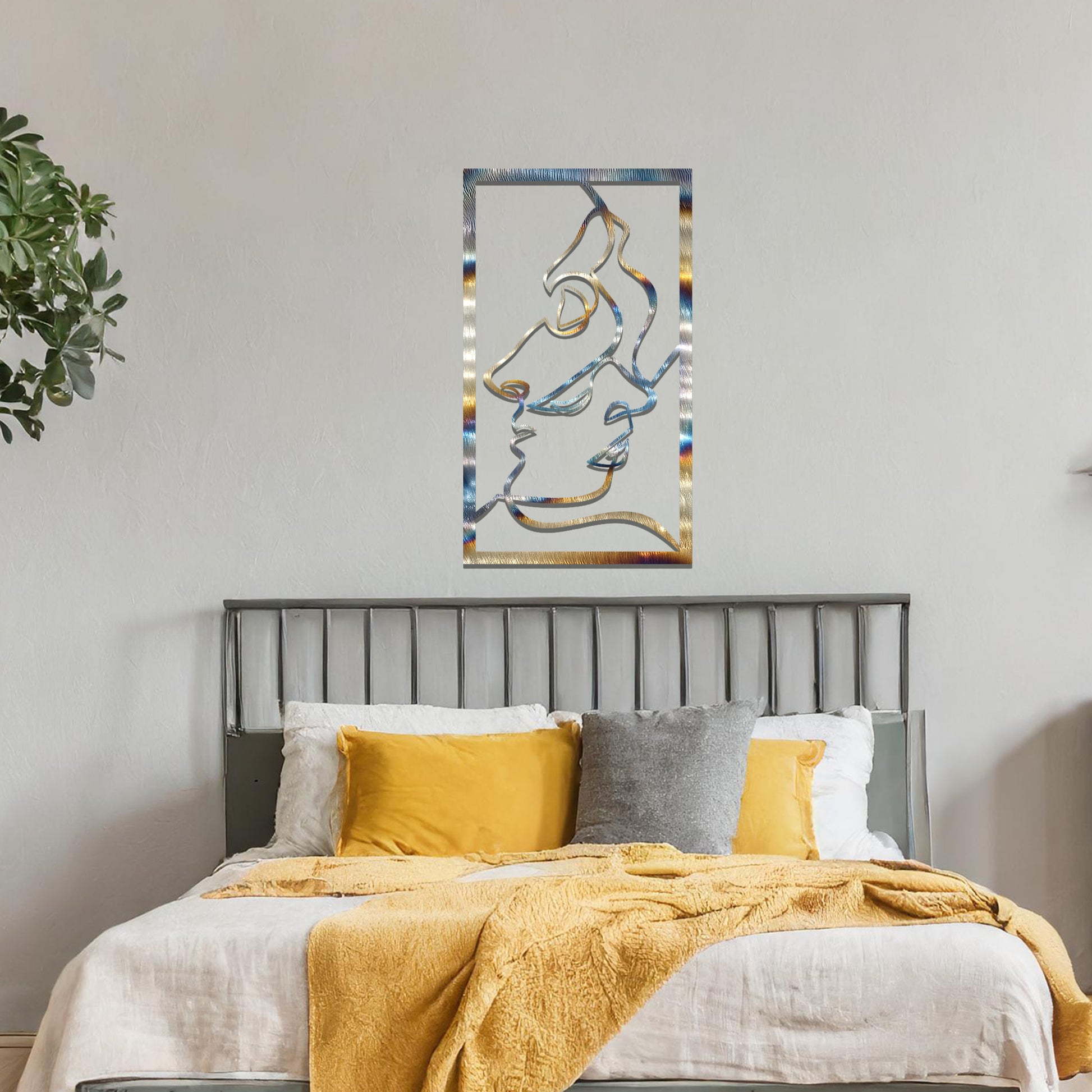 Metal wall art featuring an abstract design of two faces in profile, formed with flowing lines. The art is placed on a neutral wall within a modern office setting, contributing to a stylish and contemporary atmosphere.