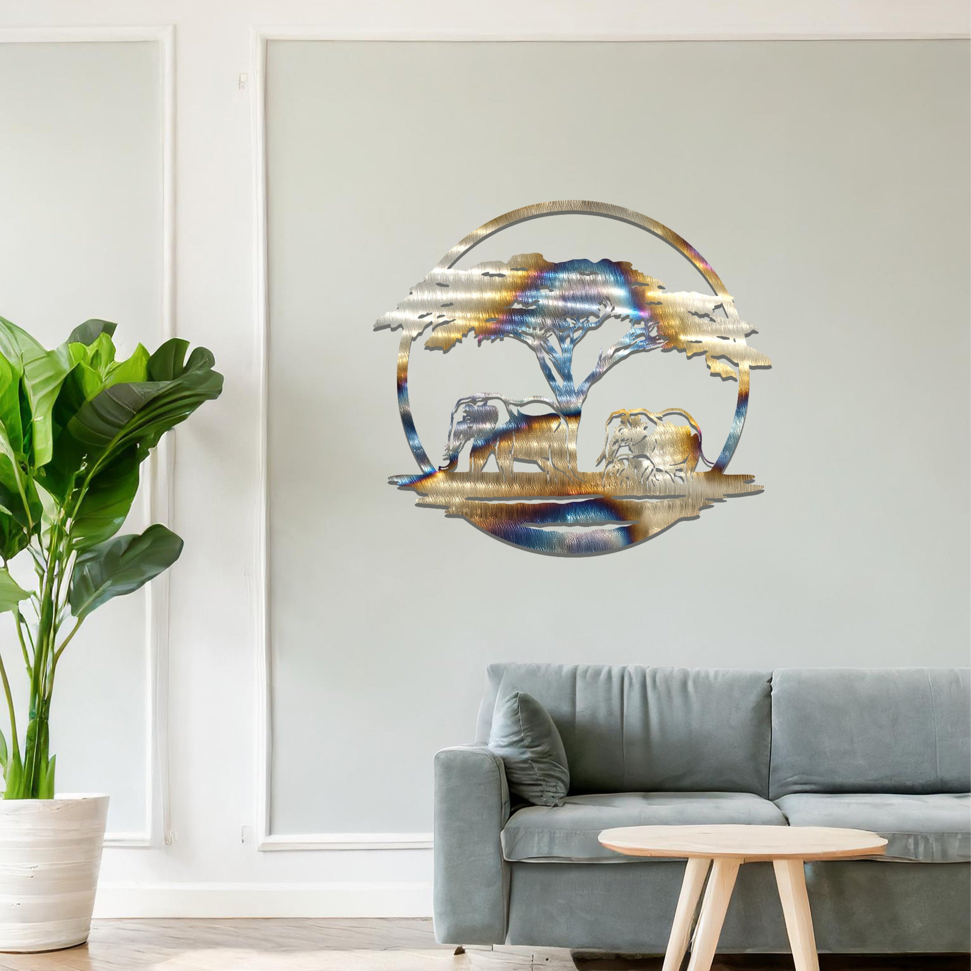 Metal wall art featuring a design of two elephants beneath a tree, framed in a circular shape. The art is placed on a neutral wall within modern room decor, creating a serene and nature-inspired atmosphere.