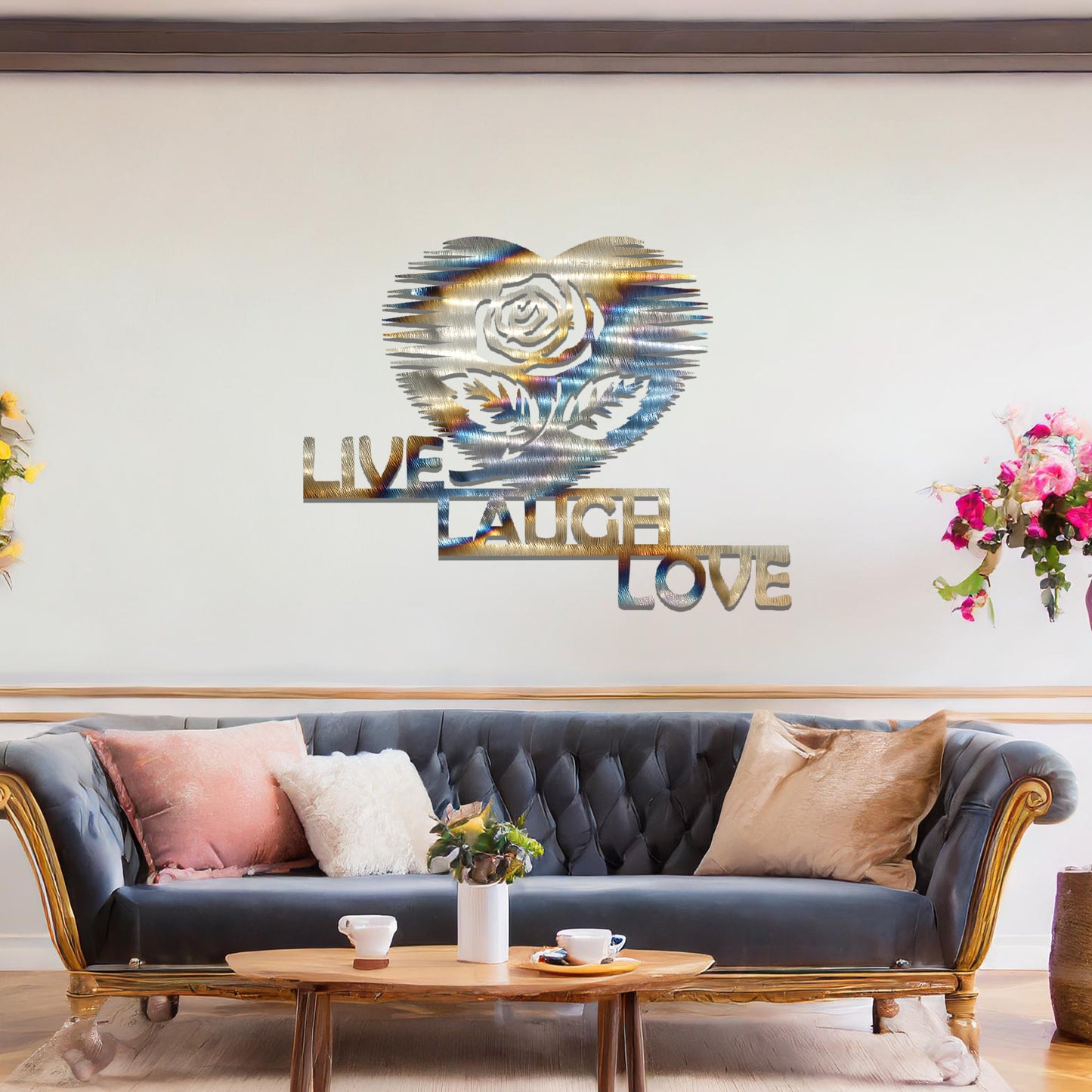 Metal wall art featuring the words "LIVE LAUGH LOVE" alongside a rose within a heart shape, with bold lines and intricate design. The art is displayed on a neutral wall within modern room decor, offering a stylish and motivational accent to the space.