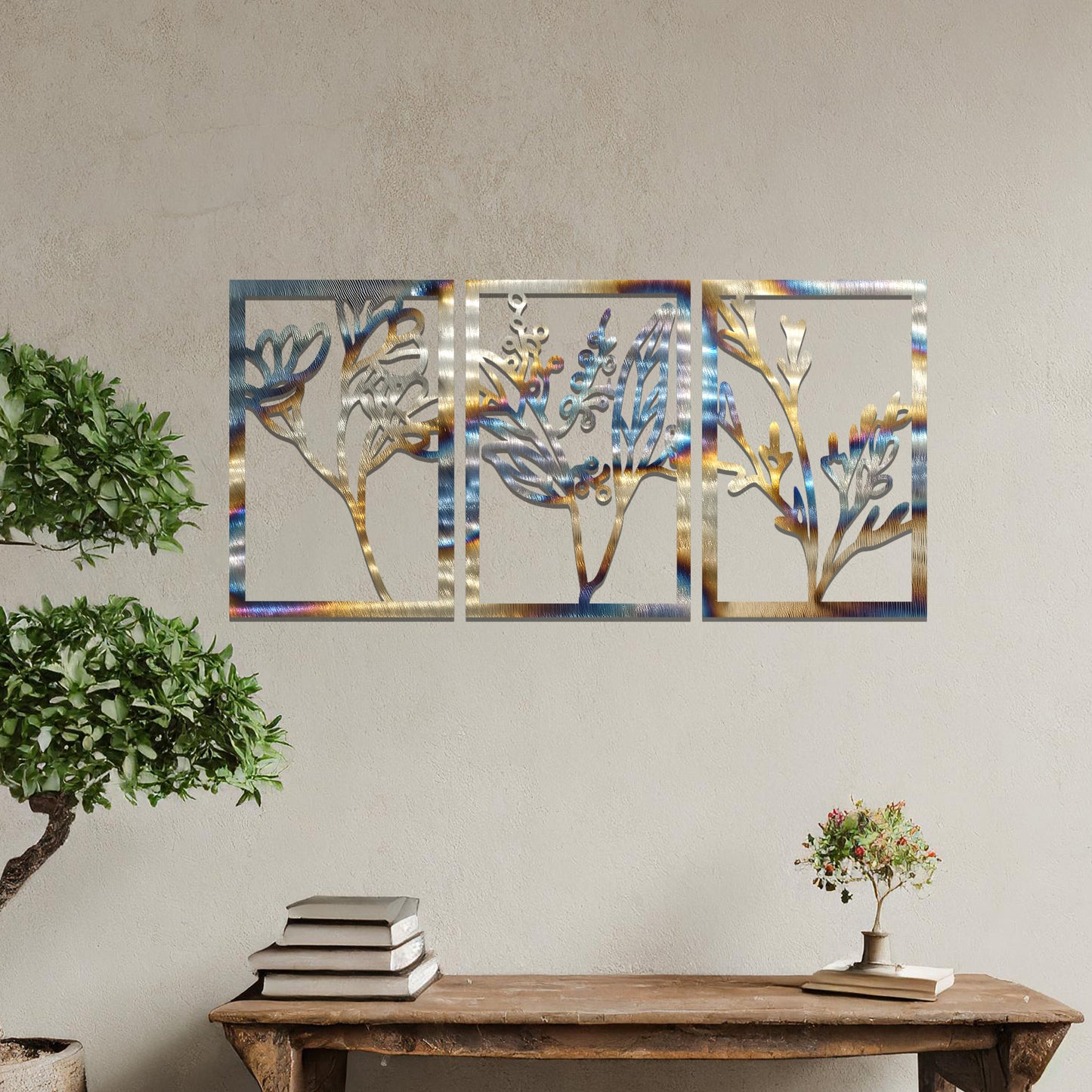 A set of three metal panels featuring intricate botanical designs, with delicate plant shapes in a flowing pattern. The artwork is placed on a neutral wall, enhancing the natural, calming atmosphere of the modern living space.