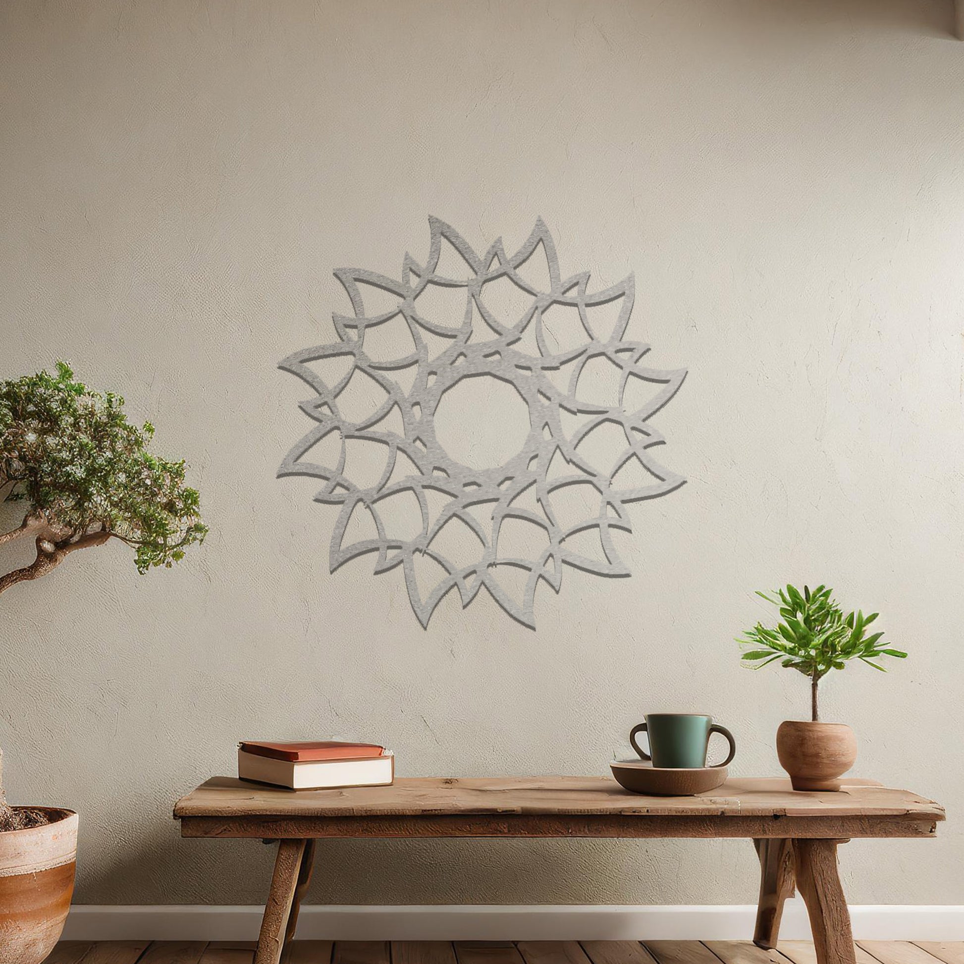 Metal wall art featuring a circular floral-inspired design with layered petal-like patterns, crafted with precise laser-cut detailing, displayed on a neutral wall within modern decor.