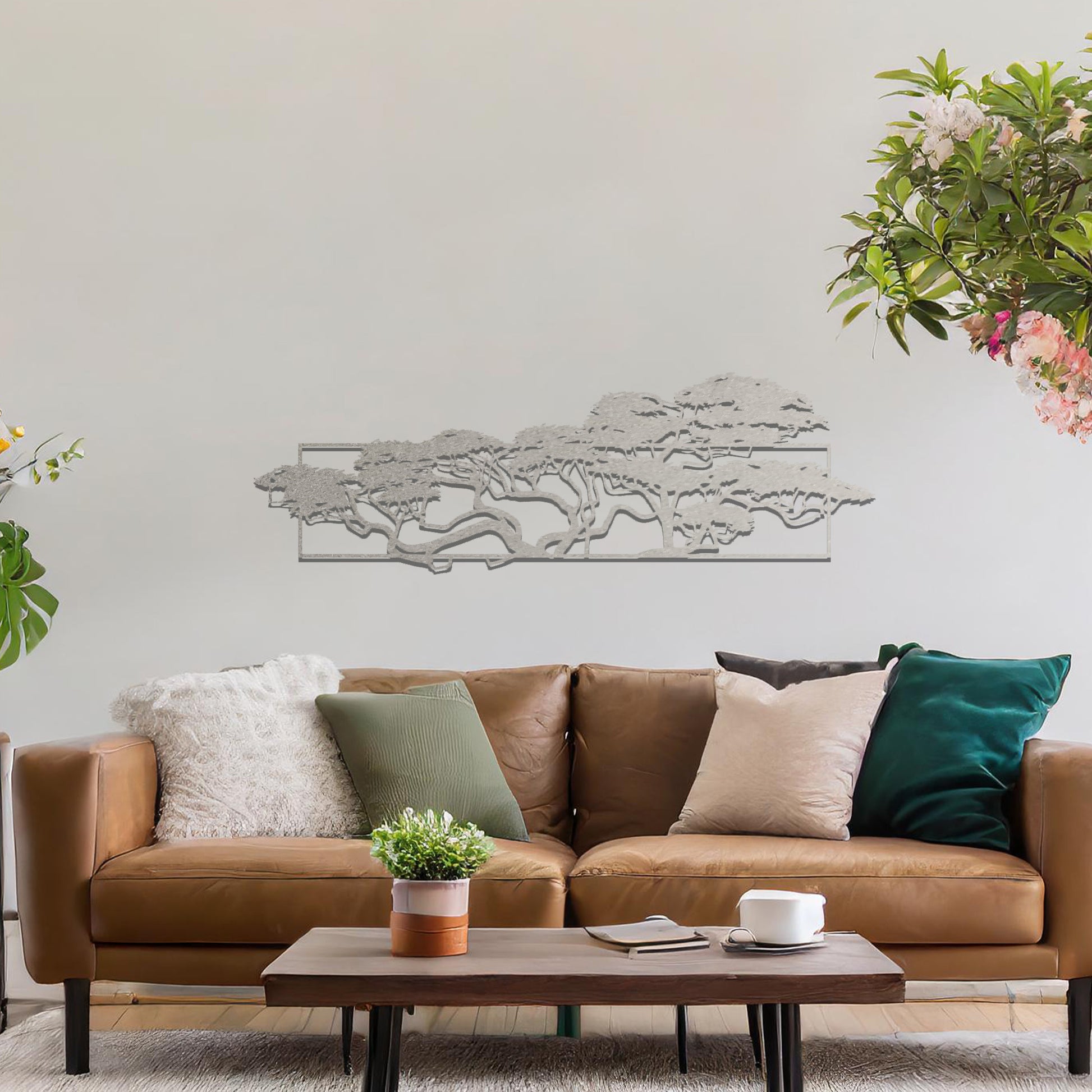 Metal wall art featuring a landscape design of a silhouette of trees with intricate branches, framed within a rectangular panel, crafted with precise laser-cut techniques, displayed on a neutral wall within modern decor.