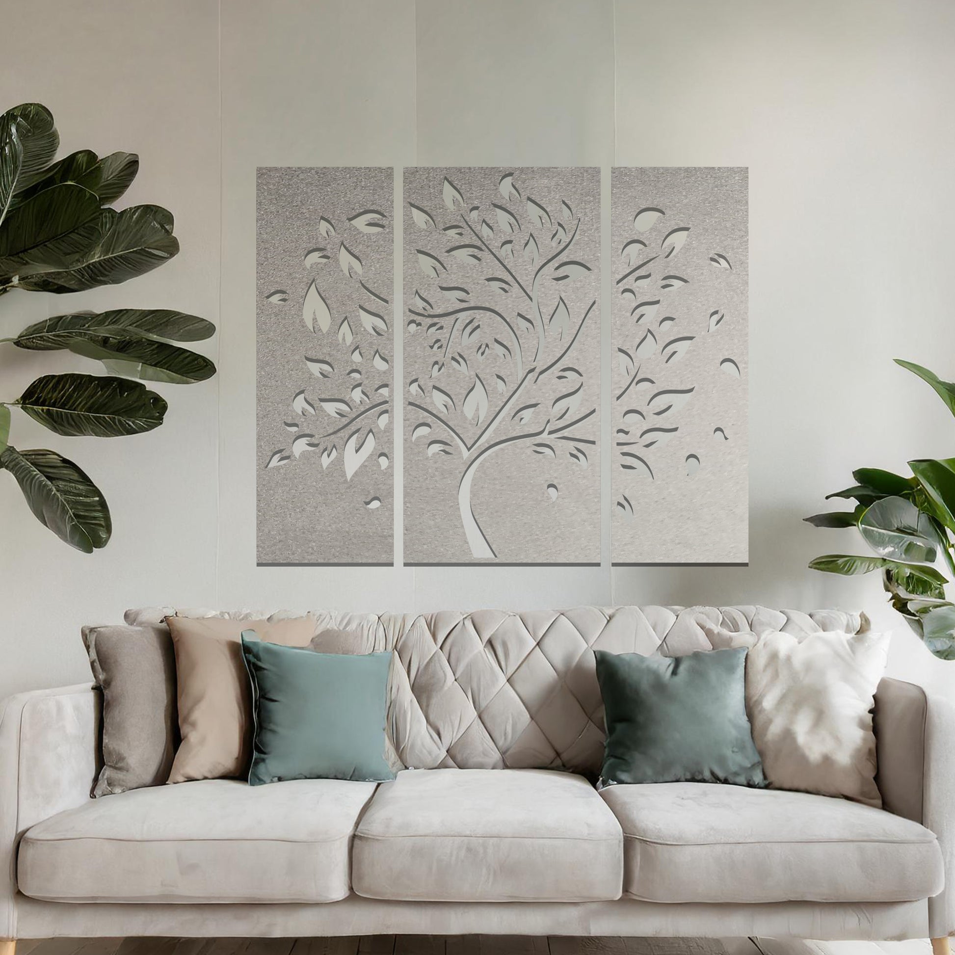 Metal wall art featuring a three-panel tree design with curved branches and delicate leaves, crafted with precise laser-cut detailing, displayed on a neutral wall within modern decor.