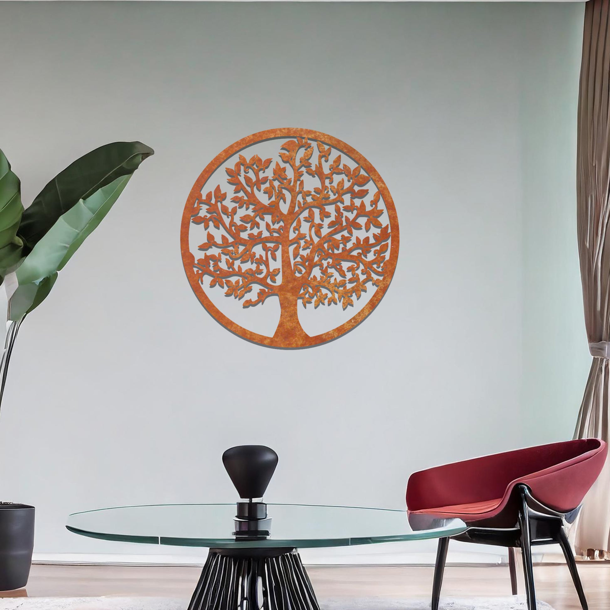 Metal wall art featuring a circular design with a detailed tree of life motif, showcasing intricate branches and leaves, mounted on a neutral wall within modern room decor. The elegant craftsmanship and symbolic design add a touch of sophistication and meaning to the space.