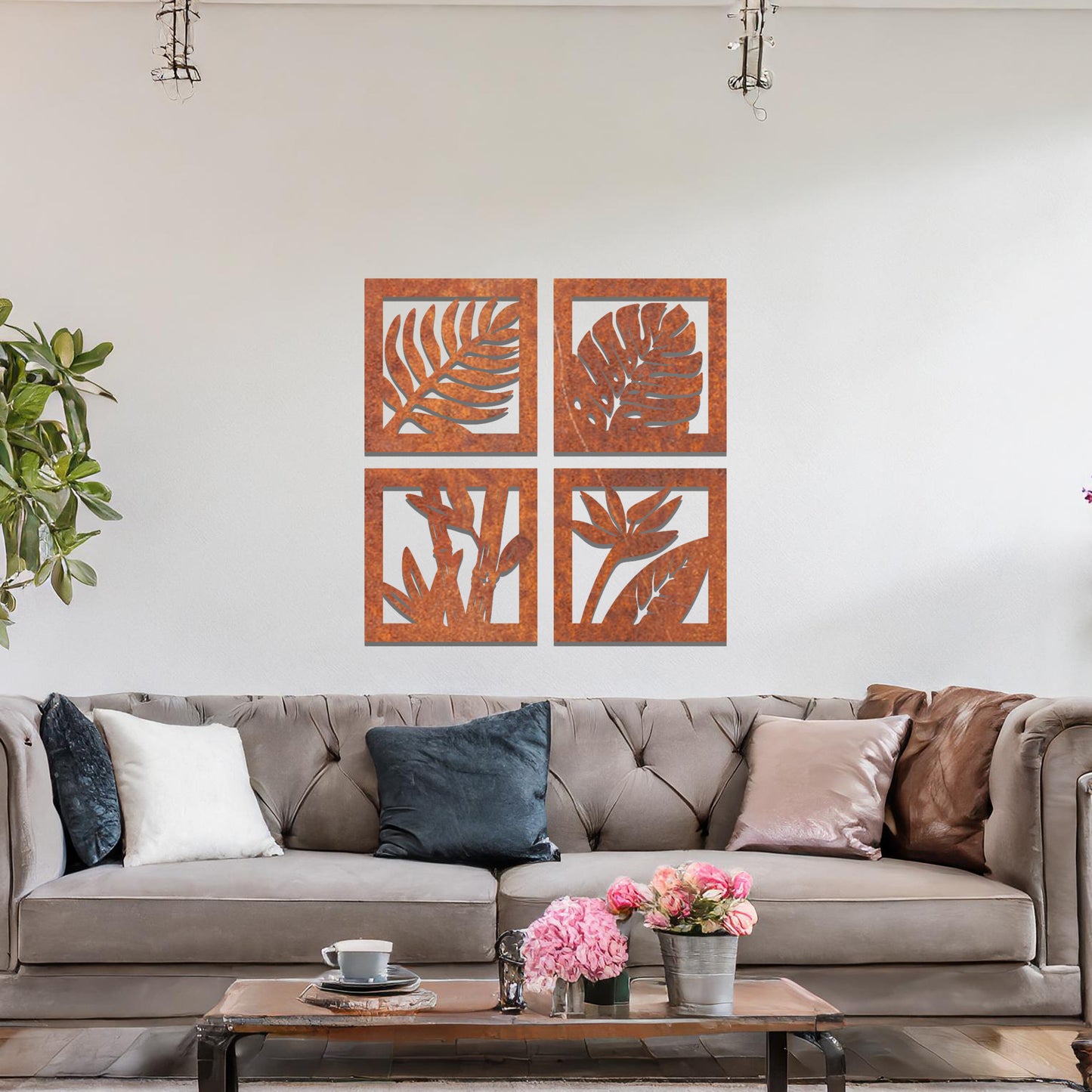 Metal wall art featuring four square panels with intricate leaf designs. The panels showcase detailed plant patterns arranged in a modern layout, mounted on a neutral wall within contemporary room decor, enhancing the room's natural ambiance