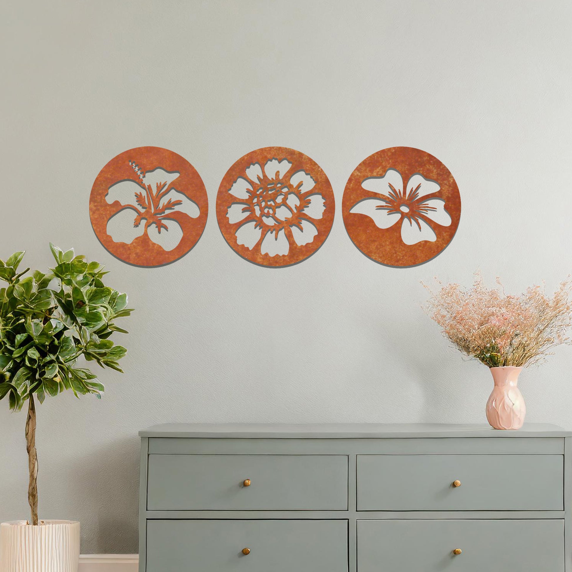 A set of three circular metal panels featuring floral designs, each panel showcasing a different flower in intricate detail. The artwork is displayed on a neutral wall, enhancing the serene and natural ambiance of the bedroom.