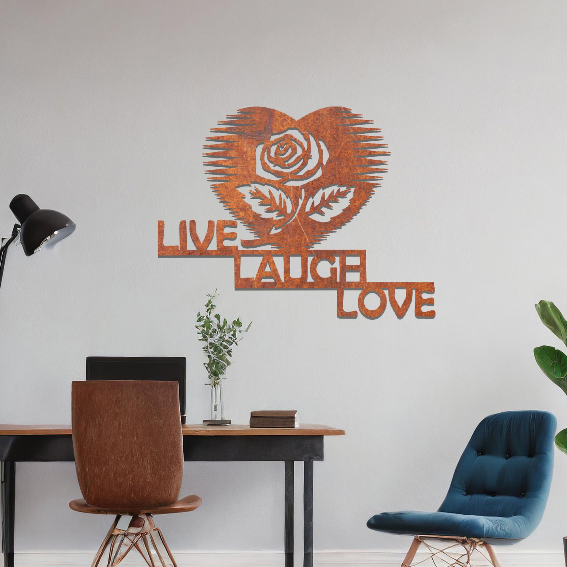 Metal wall art featuring the words "LIVE LAUGH LOVE" alongside a rose within a heart shape, with bold lines and intricate design. The art is displayed on a neutral wall within modern room decor, offering a stylish and motivational accent to the space.
