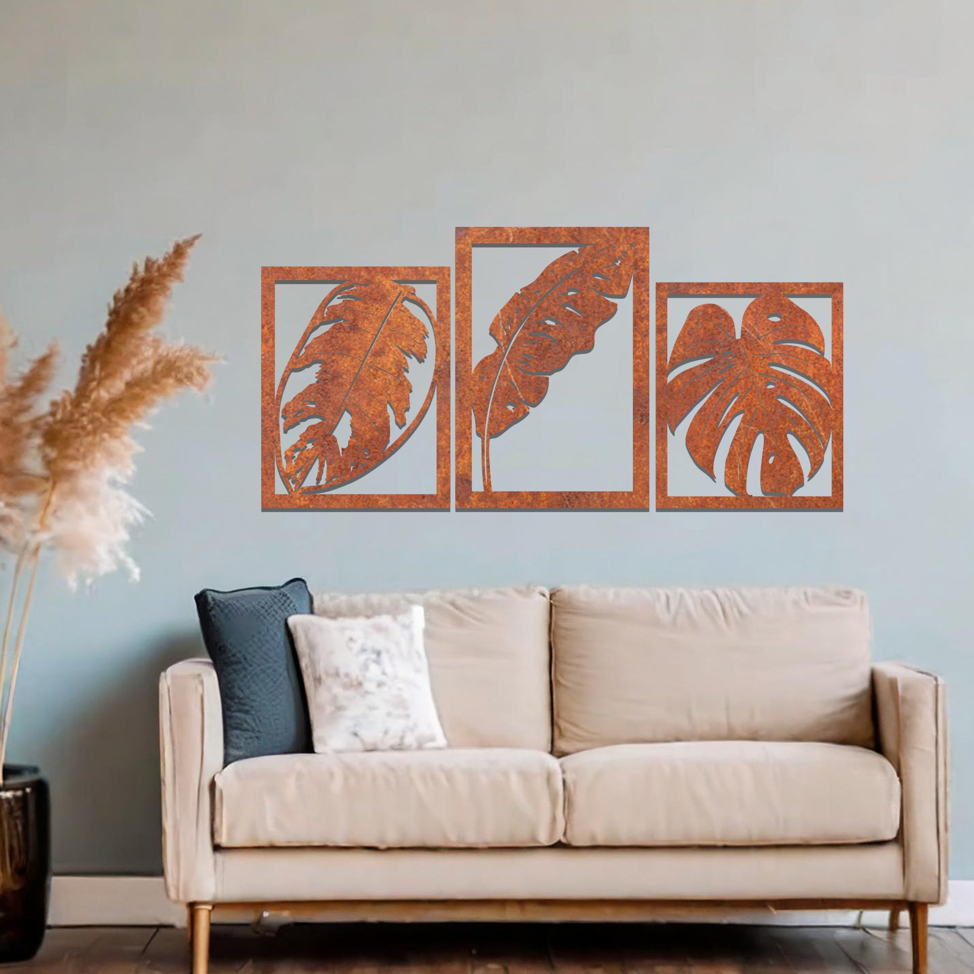 A metal wall art design featuring three leaf patterns, each in its own rectangular frame. The art is displayed on a neutral wall within a modern office space, enhancing the environment with its natural and minimalist appeal.