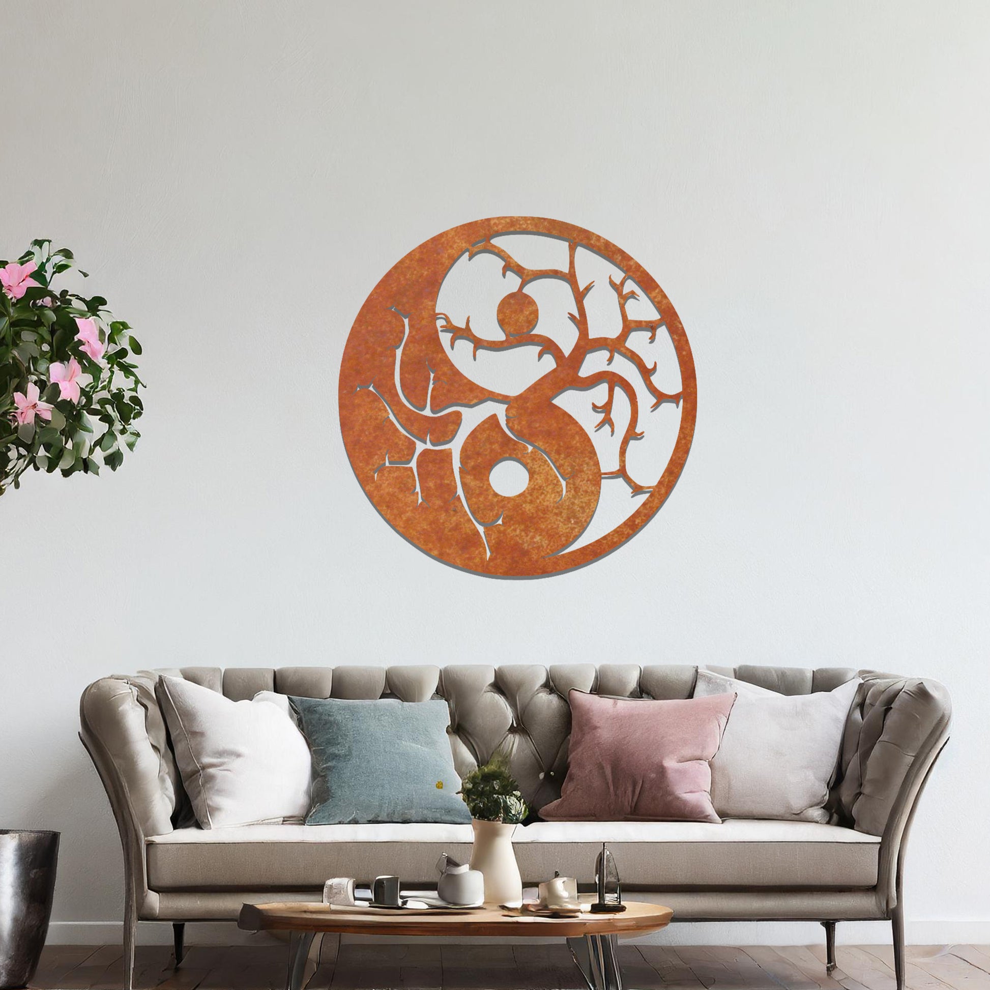 A metal wall art design featuring a yin and yang symbol intertwined with tree branches. The contrasting sides of the design represent balance, with the left side showing delicate branches on a dark background, and the right side showcasing branches on a light background.
