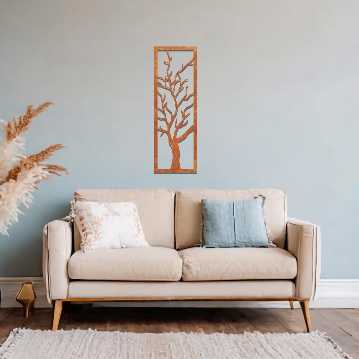 Metal wall art featuring a vertical design of a bare tree with intricate branches, mounted on a neutral wall within elegant room decor. The minimalist silhouette of the tree adds a sophisticated, natural focal point to the space.