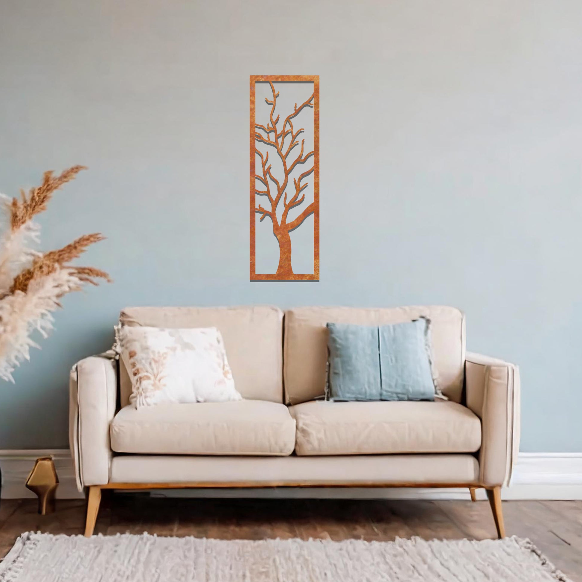 Metal wall art featuring a vertical design of a bare tree with intricate branches, mounted on a neutral wall within elegant room decor. The minimalist silhouette of the tree adds a sophisticated, natural focal point to the space.