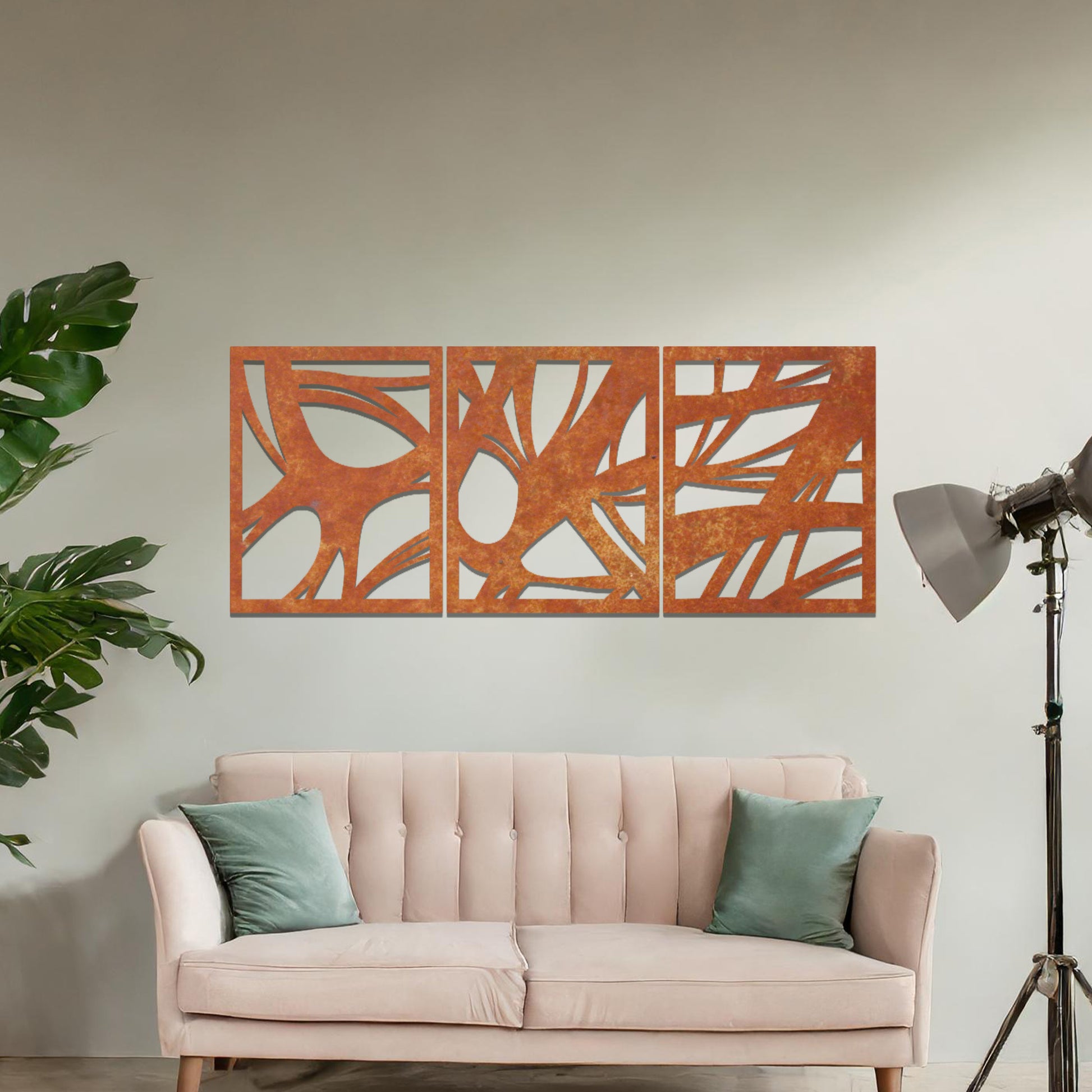 Metal wall art featuring a three-panel design with abstract organic shapes, mounted on a neutral wall within modern decor. The rust finish and fluid, nature-inspired forms create a striking focal point, enhancing the room’s natural aesthetic.