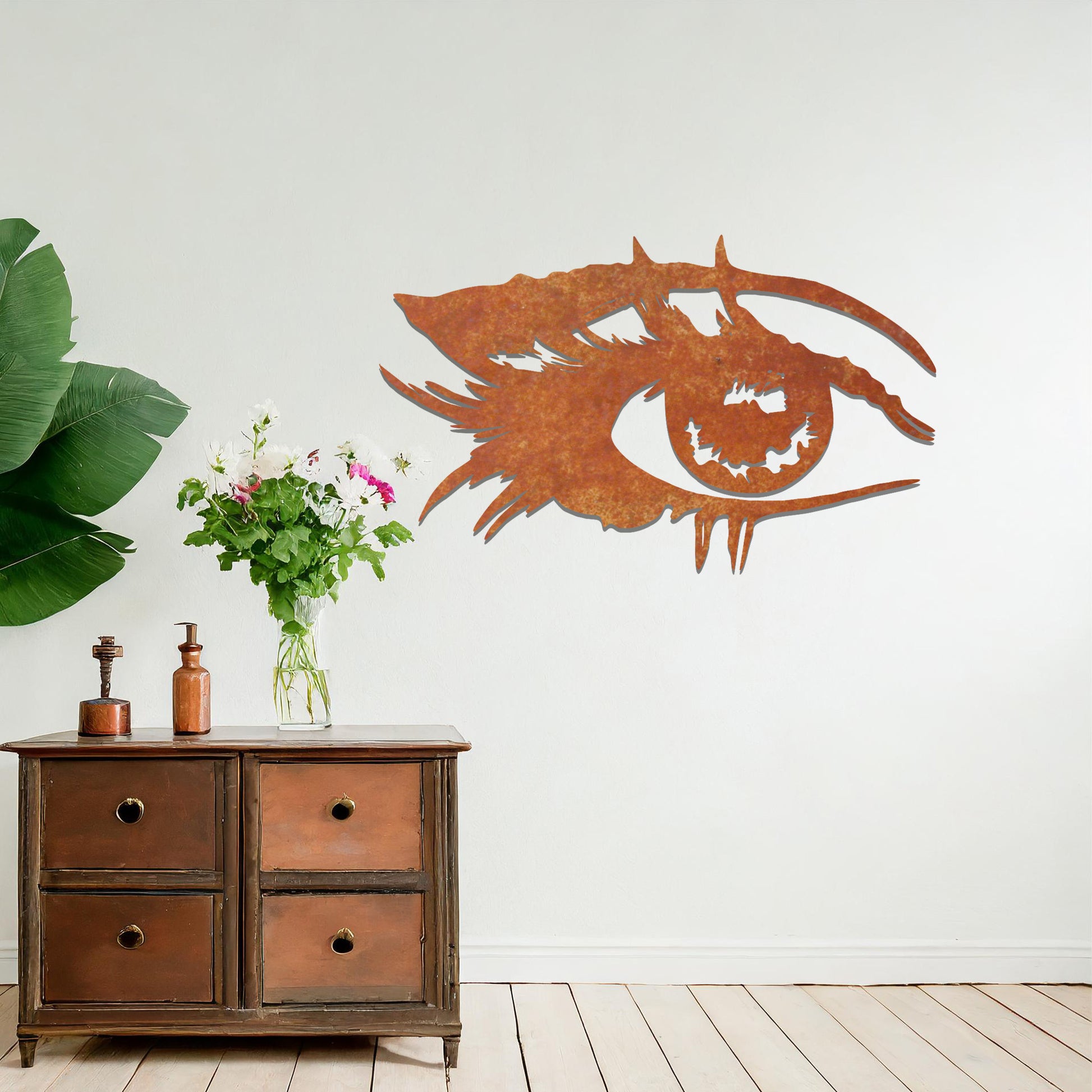Striking metal wall art featuring a bold and artistic eye design with intricate detailing, mounted on a neutral wall within modern room decor. The focus is entirely on the creative and contemporary craftsmanship of the wall art, enhancing the space's aesthetic appeal.