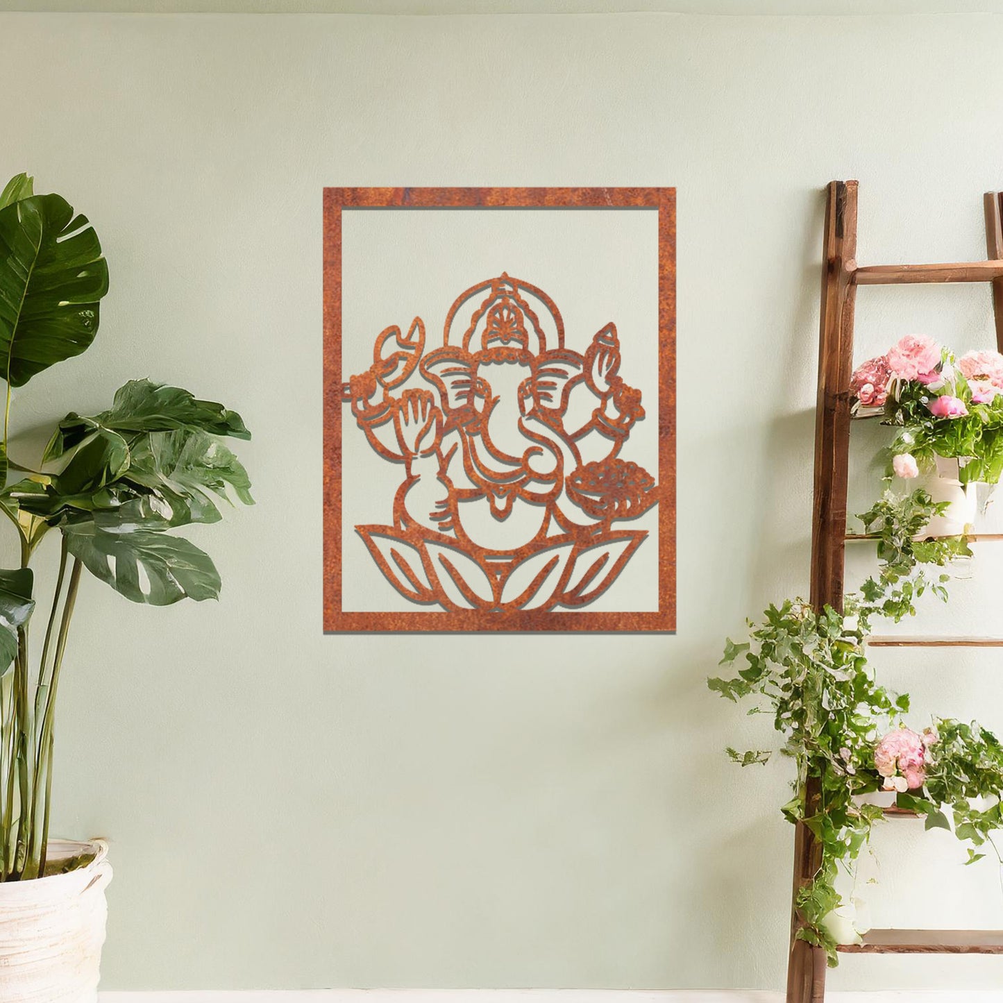 Metal wall art featuring a rectangular design of Lord Ganesha sitting on a lotus, showcasing intricate detailing of the deity's form and symbolic elements, mounted on a neutral wall within modern room decor. The craftsmanship adds a spiritual and artistic touch to the space.
