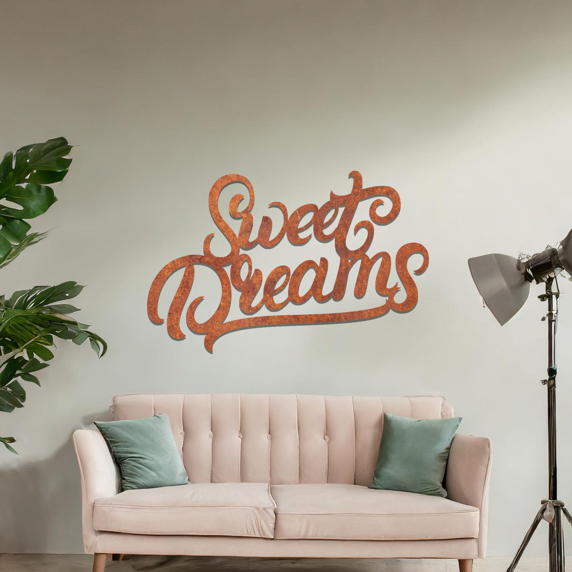 Metal wall art featuring the phrase "Sweet Dreams" in an elegant cursive font, mounted on a neutral wall within modern room decor. The artistic typography adds a charming and comforting focal point, perfect for enhancing the cosy ambiance of the space.