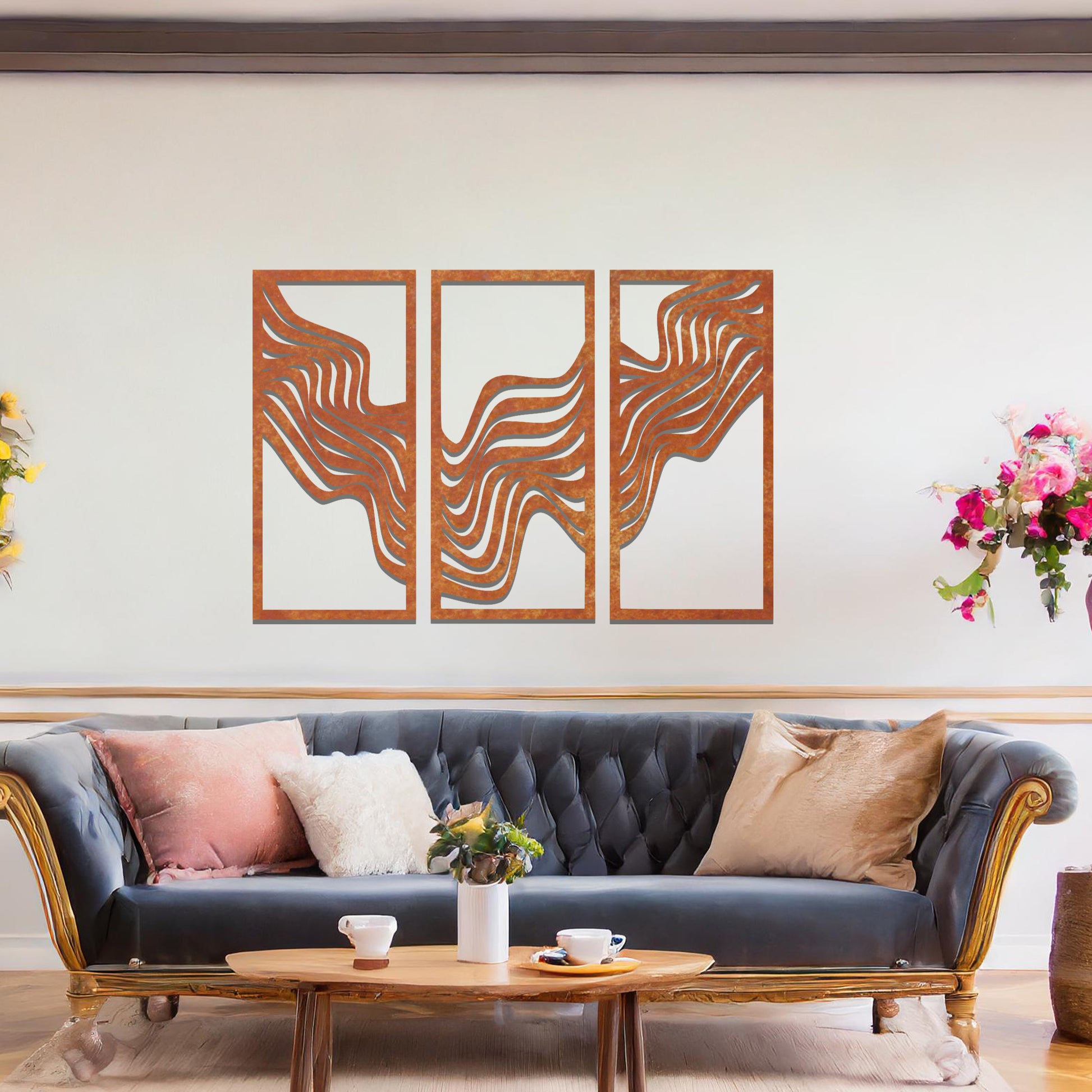 Metal wall art set of three panels featuring flowing, wave-like patterns. The design flows across the panels with a smooth, dynamic movement. The art is placed on a neutral wall in a modern living room, enhancing the space with a sleek, contemporary feel.