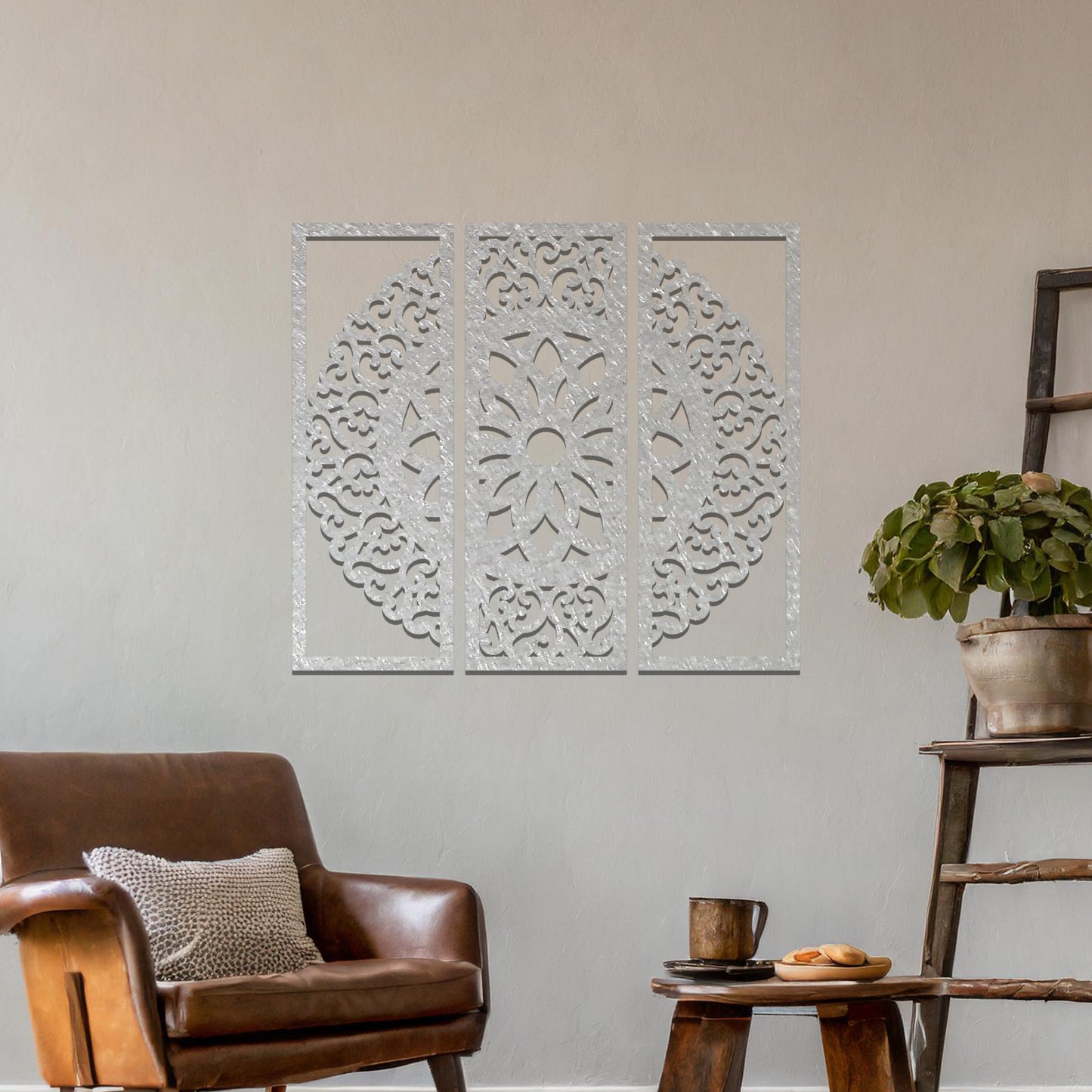 A metal wall art design split into three panels, featuring an intricate floral mandala pattern. The decorative piece is displayed on a neutral wall, adding an elegant, modern touch to the room's decor.