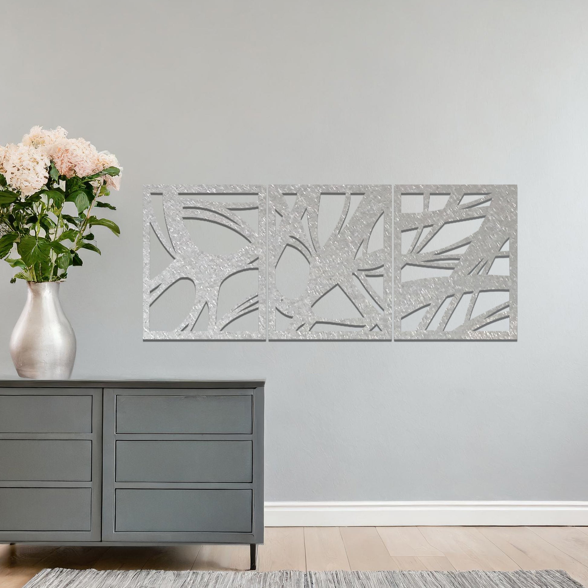 Metal wall art featuring a three-panel design with abstract organic shapes, mounted on a neutral wall within modern decor. The rust finish and fluid, nature-inspired forms create a striking focal point, enhancing the room’s natural aesthetic.
