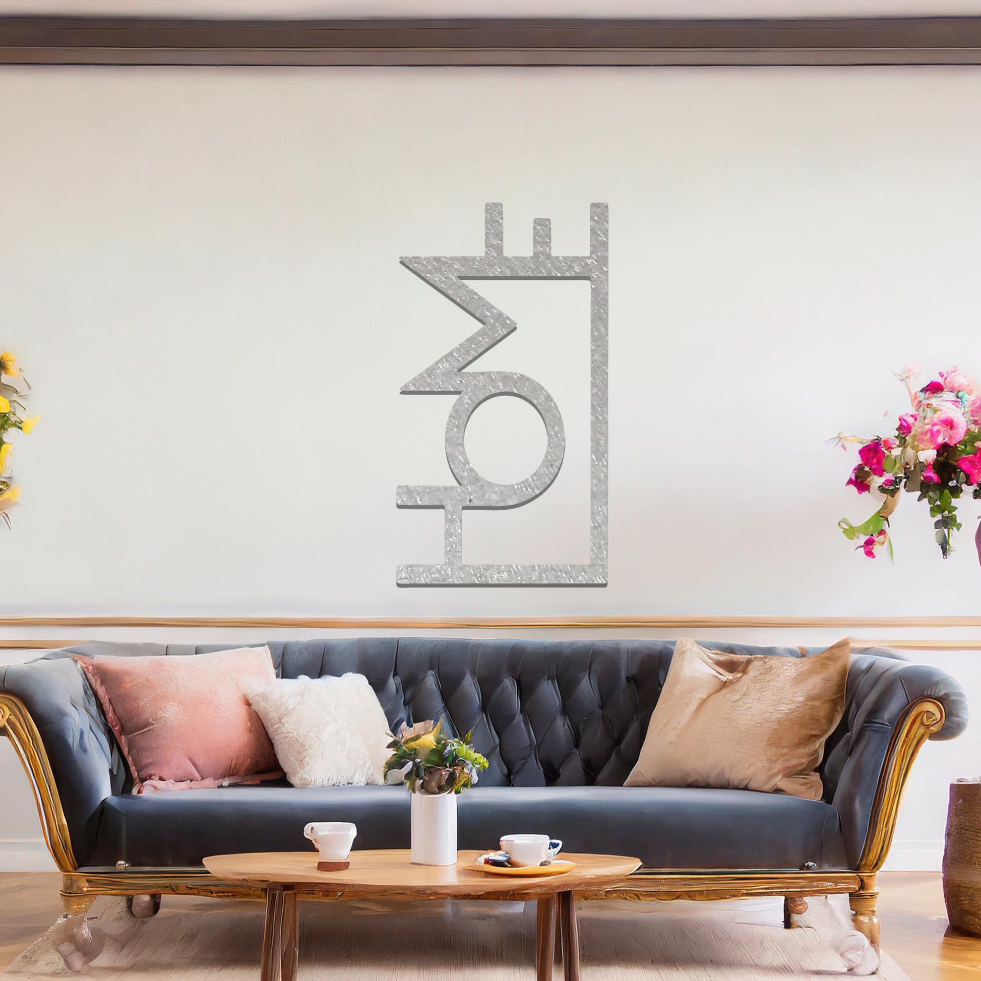 A modern metal wall art design featuring the word "HOME" in bold, geometric typography with an innovative, angular twist. The artwork is displayed on a neutral wall in a contemporary room setting.