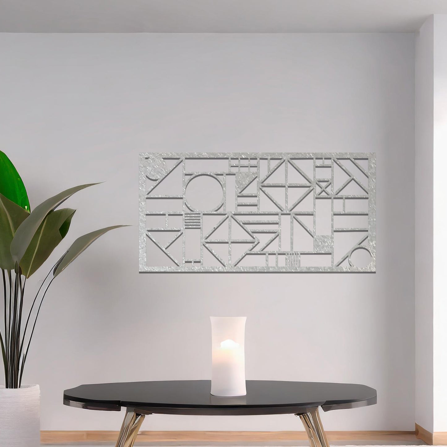 Metal wall art with a geometric design, featuring various abstract shapes, lines, and angles arranged in a structured composition. The art is placed on a neutral wall within modern room decor, adding an artistic touch to the space.