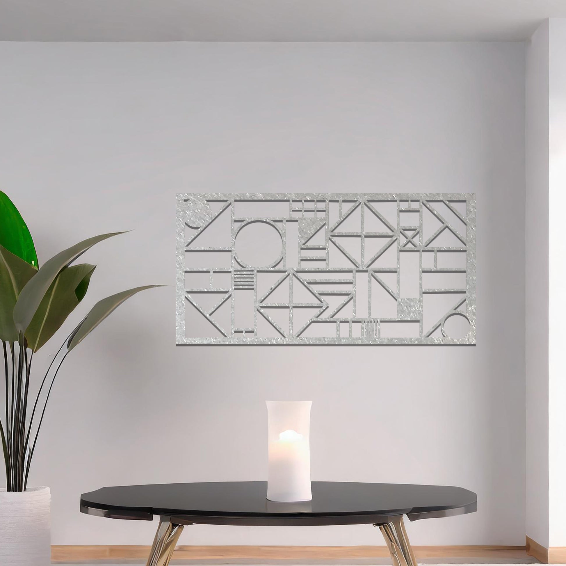 Metal wall art with a geometric design, featuring various abstract shapes, lines, and angles arranged in a structured composition. The art is placed on a neutral wall within modern room decor, adding an artistic touch to the space.