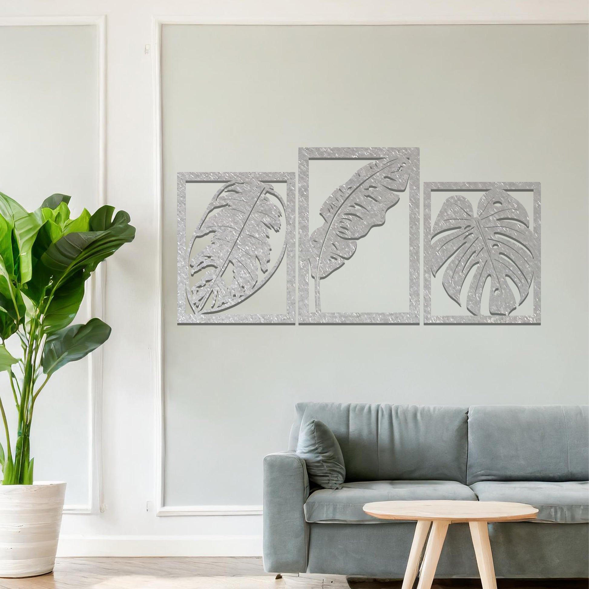 A metal wall art design featuring three leaf patterns, each in its own rectangular frame. The art is displayed on a neutral wall within a modern office space, enhancing the environment with its natural and minimalist appeal.