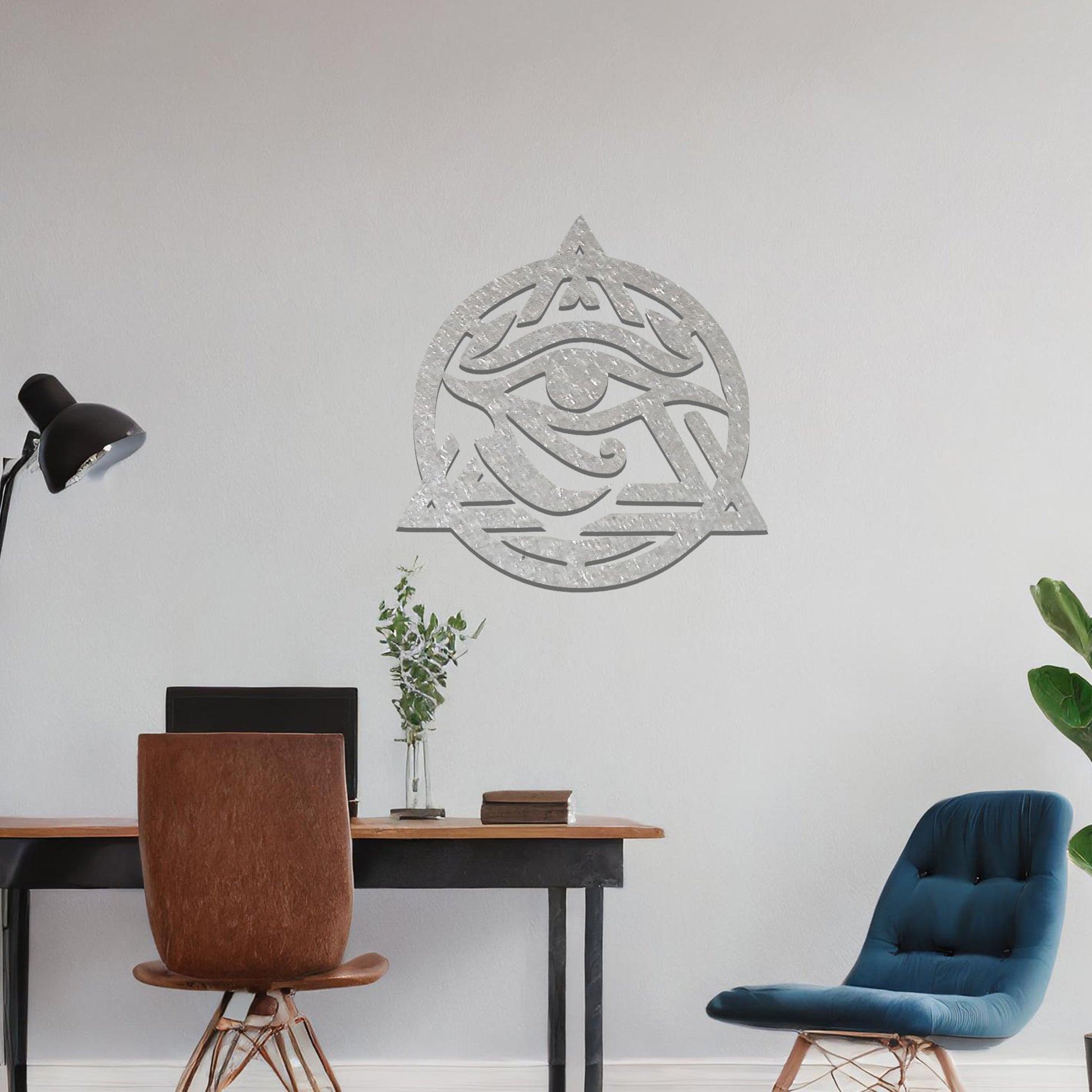 Metal wall art featuring an intricate design of the Eye of Horus, enclosed within a geometric triangle and circle. The artwork is placed on a neutral wall in a modern living room setting, adding to the contemporary decor.