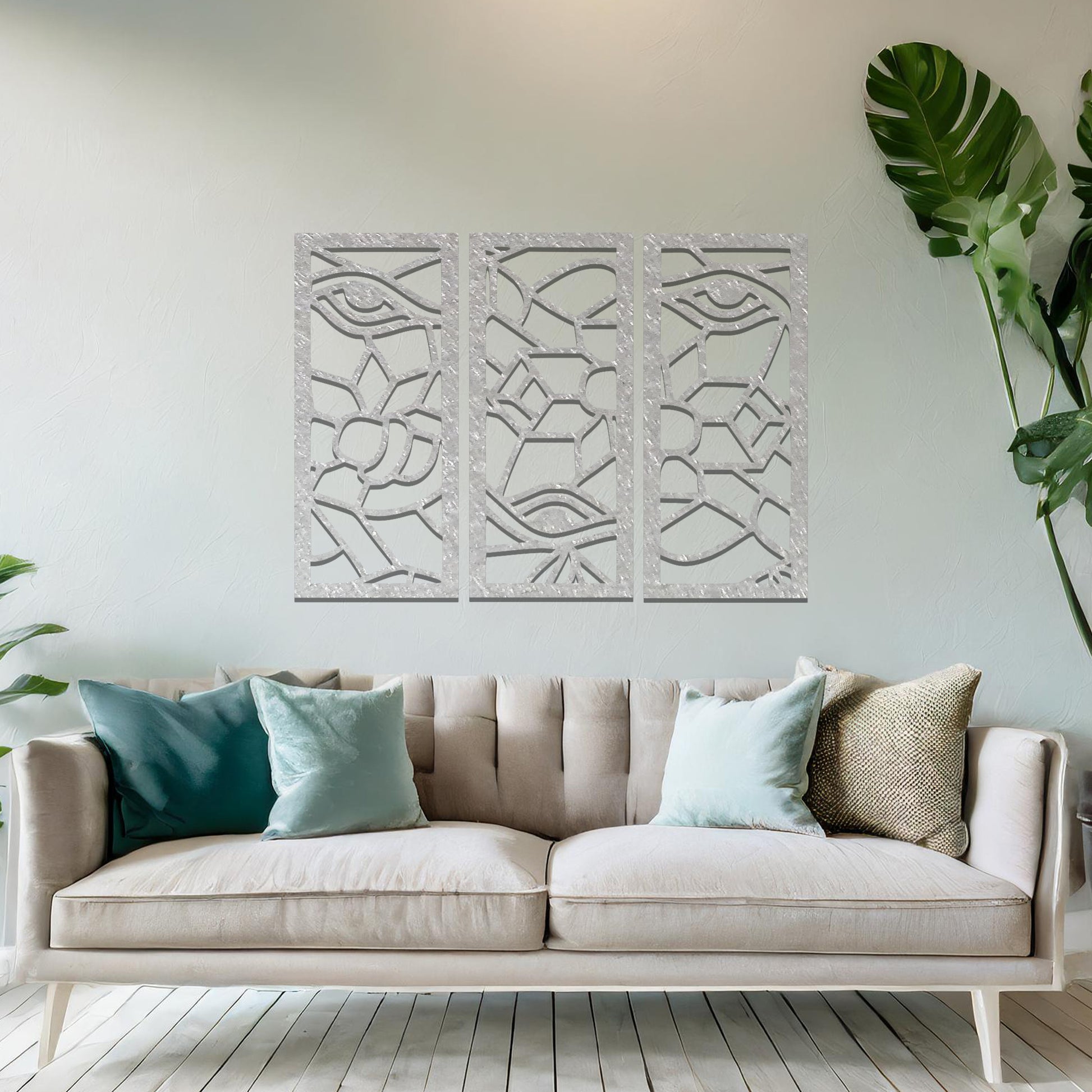 Decorative metal wall art featuring a set of three geometric panels with intricate abstract designs, mounted on a neutral wall within modern room decor. The focus is on the unique craftsmanship and harmonious composition of the wall art, enhancing the contemporary aesthetic of the space.