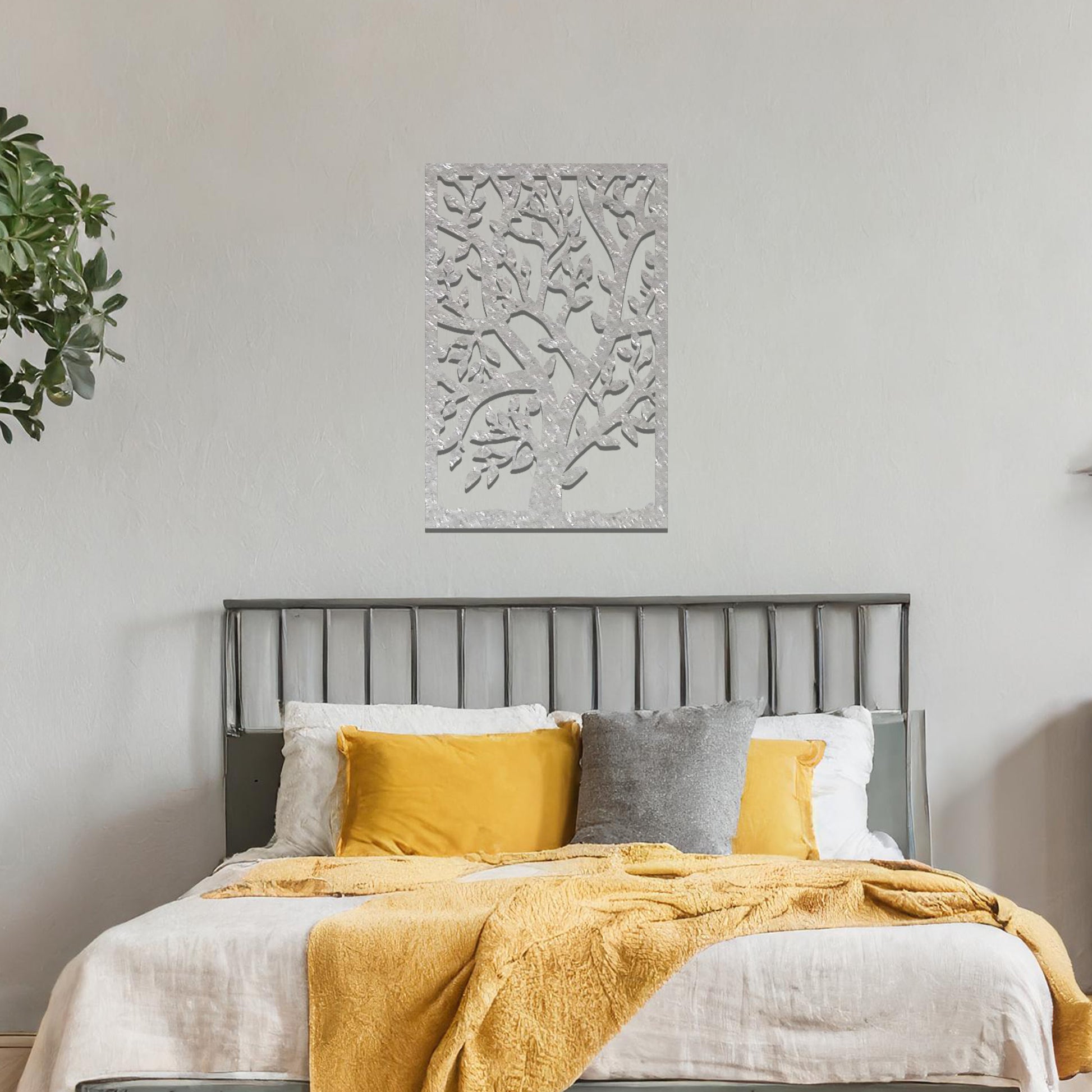 Metal wall art featuring a tree with detailed branches and leaves, enclosed in a rectangular frame. The artwork is displayed on a neutral wall within a modern office space, complemented by a stylish desk, chair, and greenery.