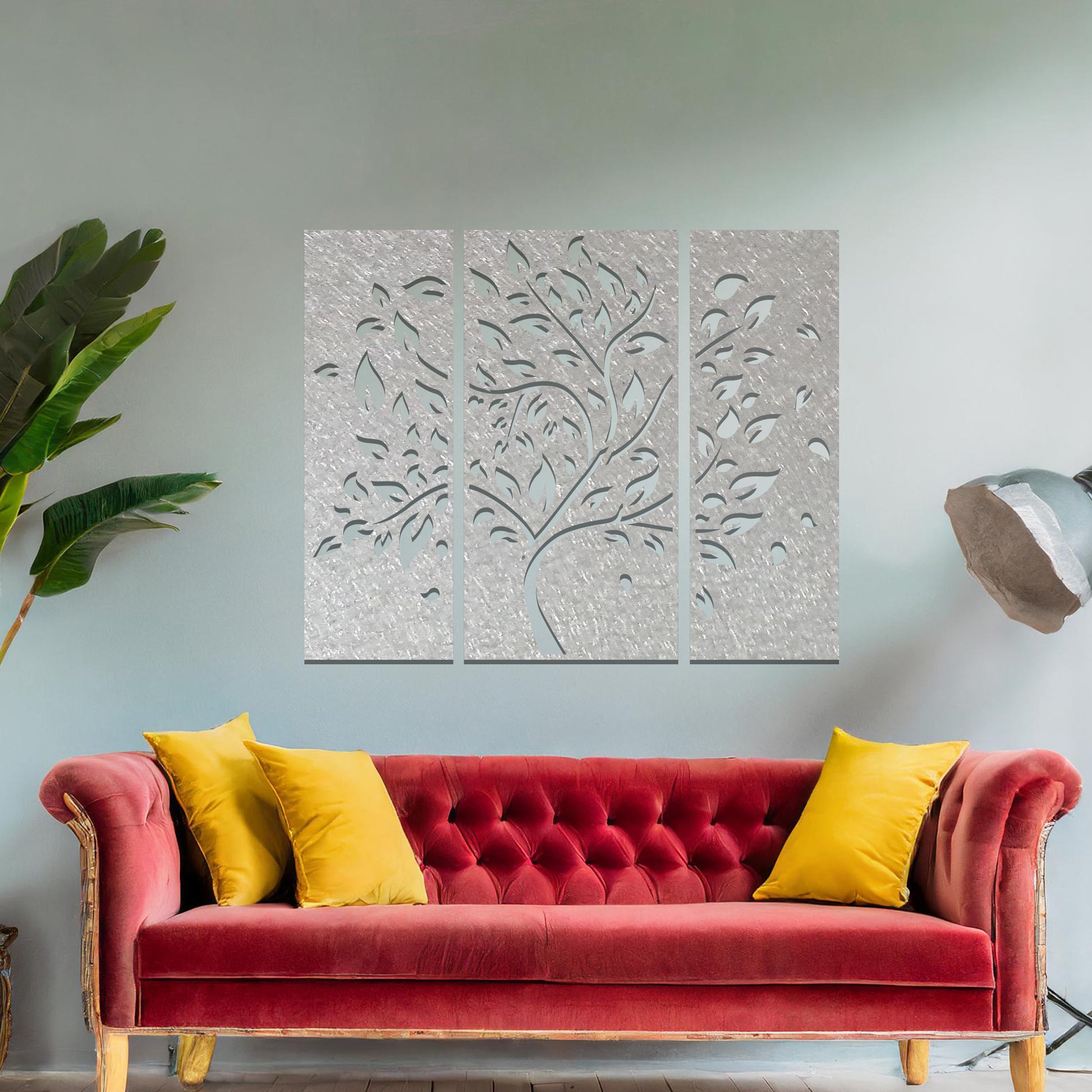 Metal wall art featuring a three-panel tree design with curved branches and delicate leaves, crafted with precise laser-cut detailing, displayed on a neutral wall within modern decor.