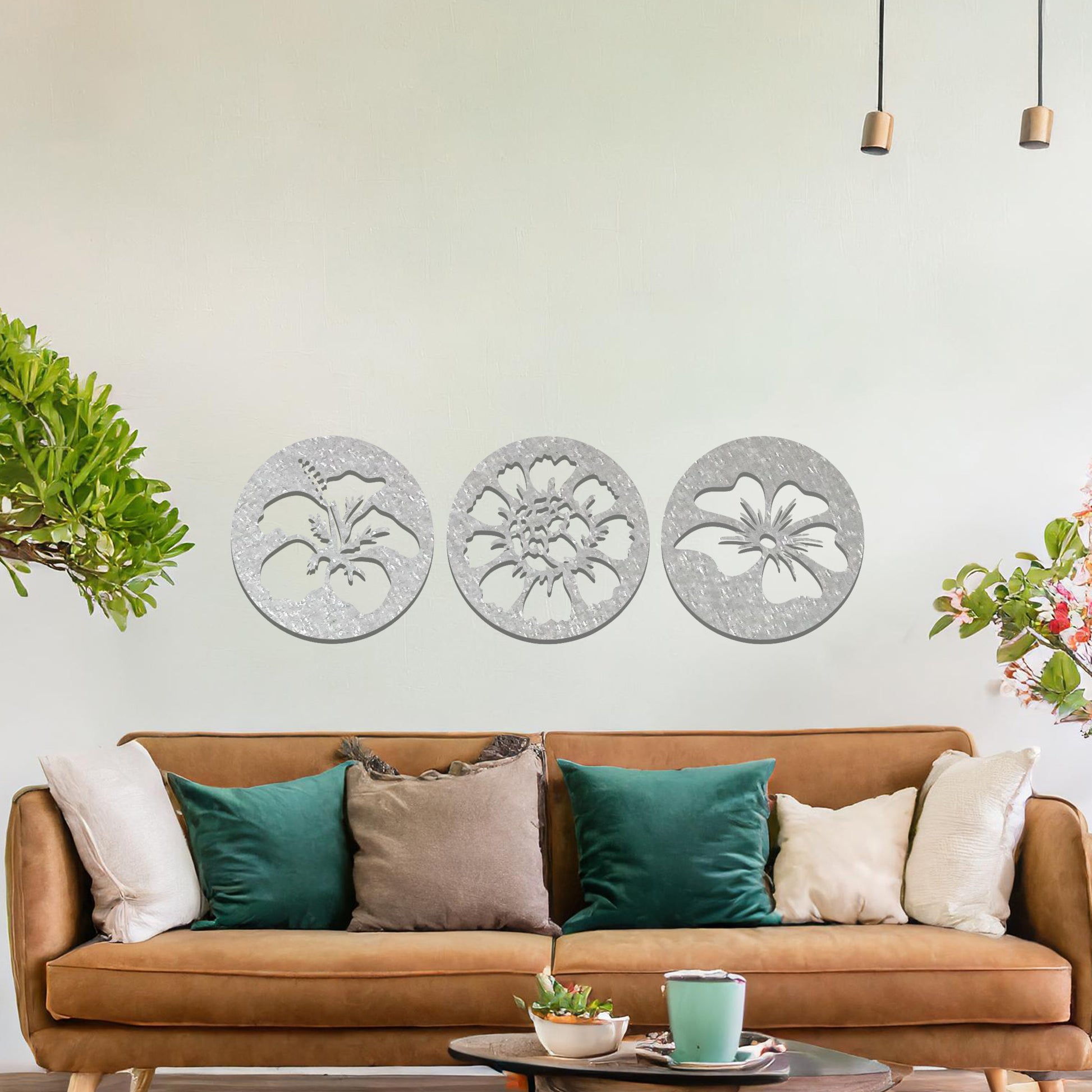 A set of three circular metal panels featuring floral designs, each panel showcasing a different flower in intricate detail. The artwork is displayed on a neutral wall, enhancing the serene and natural ambiance of the bedroom.