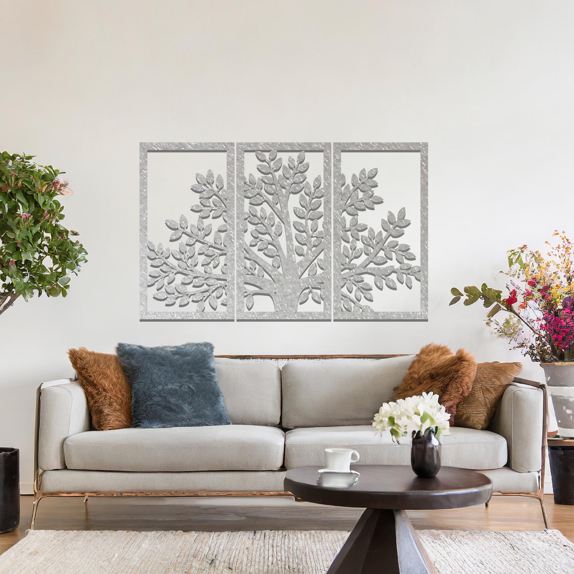 Metal wall art featuring a three-panel tree design with a detailed trunk, branches, and clustered leaves, crafted with precise laser-cut detailing, displayed on a neutral wall within modern decor.