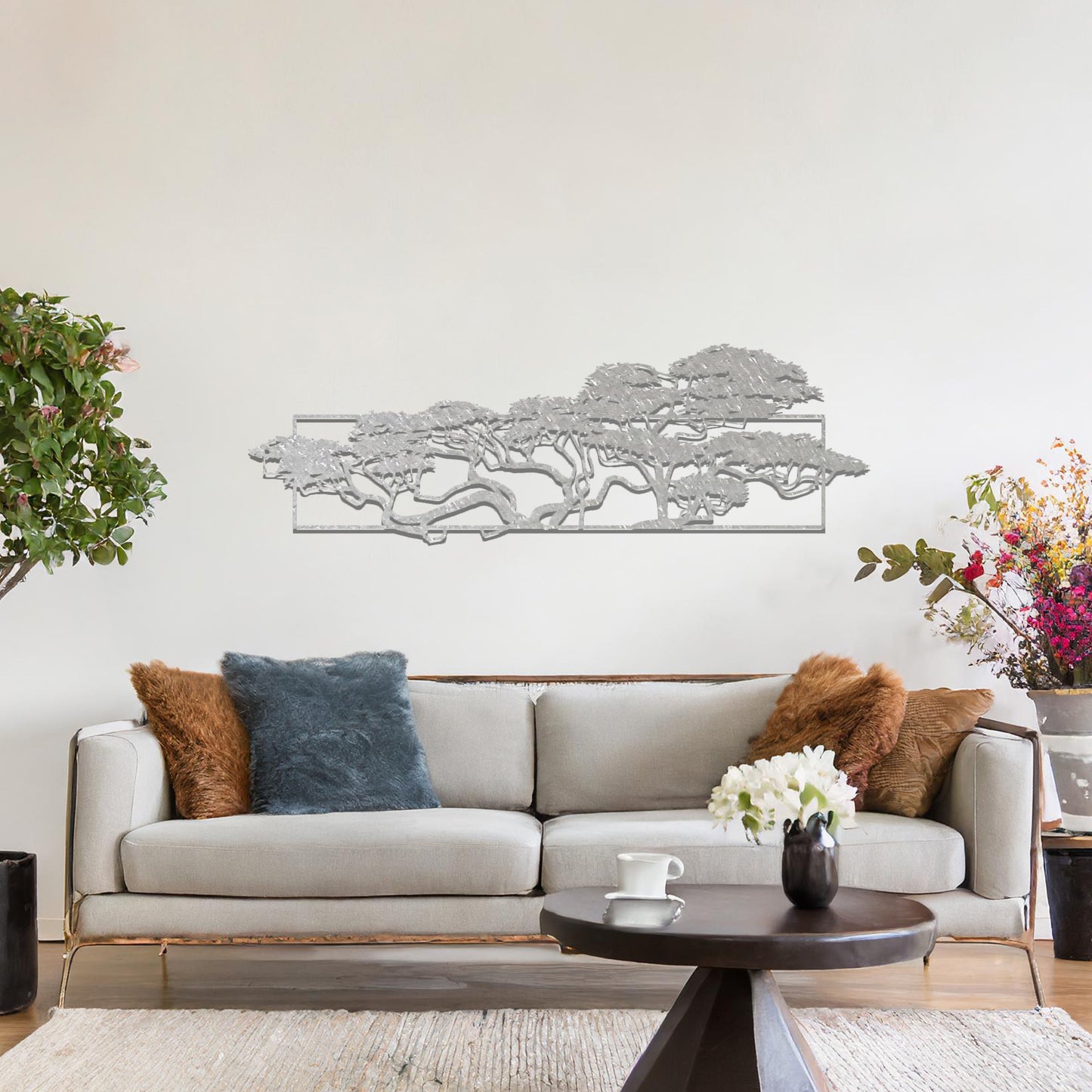 Metal wall art featuring a landscape design of a silhouette of trees with intricate branches, framed within a rectangular panel, crafted with precise laser-cut techniques, displayed on a neutral wall within modern decor.
