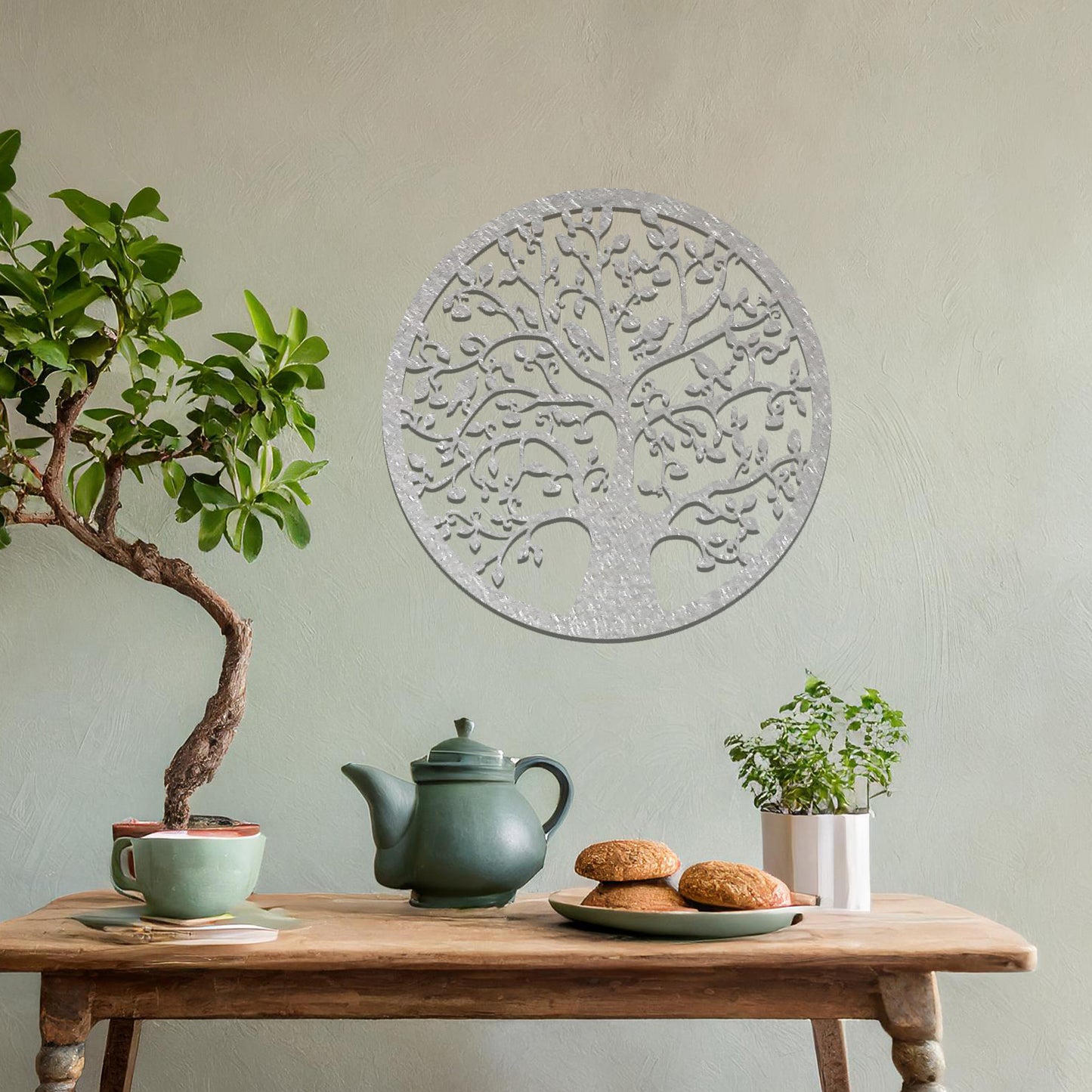 Metal wall art featuring a circular tree design with intricate branches and leaves, showcasing a detailed and balanced composition, displayed on a neutral wall within modern decor.