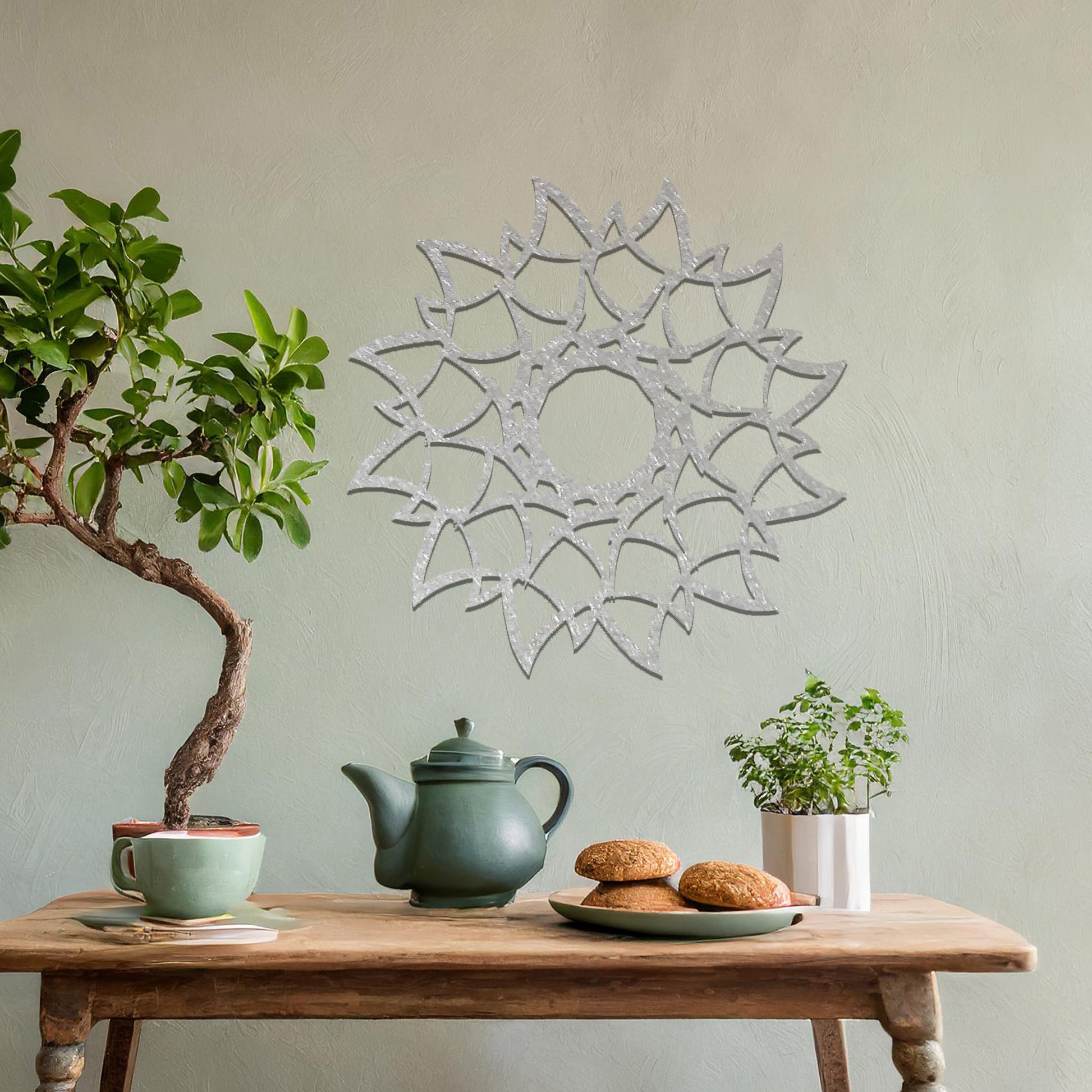 Metal wall art featuring a circular floral-inspired design with layered petal-like patterns, crafted with precise laser-cut detailing, displayed on a neutral wall within modern decor.