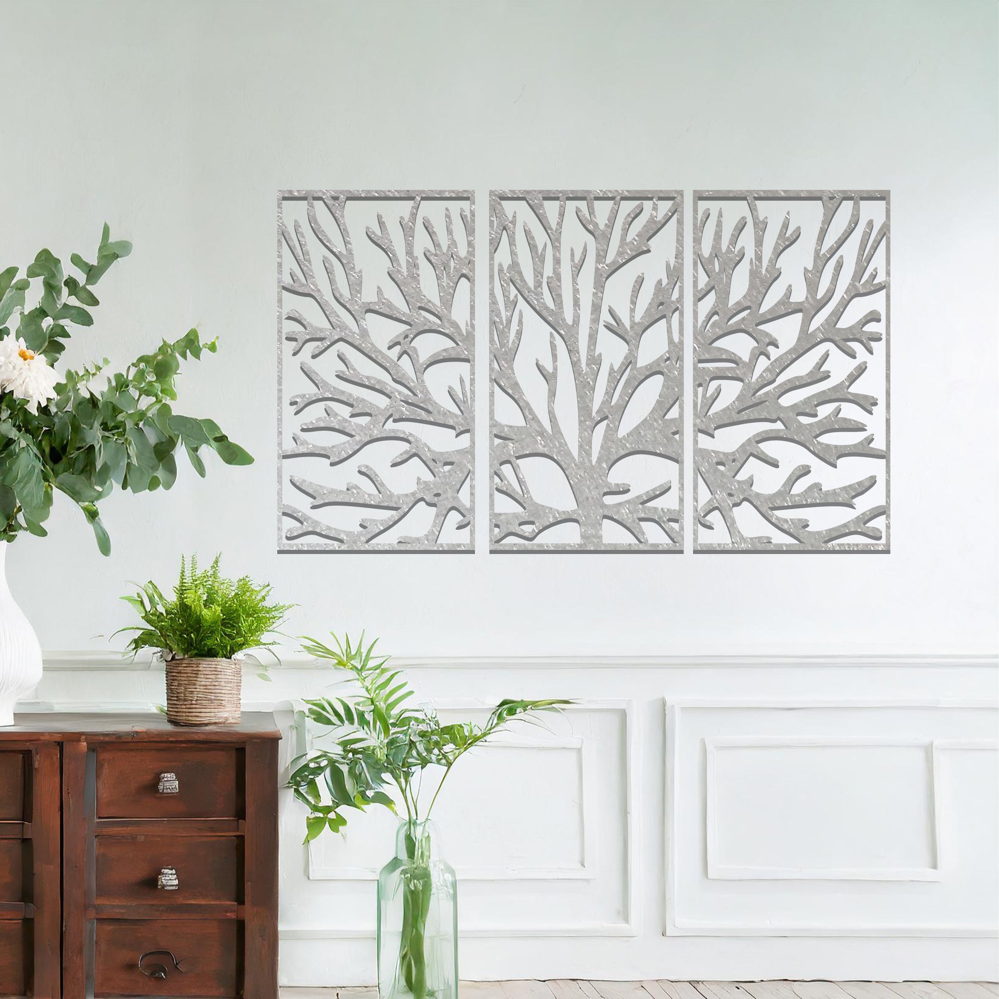 Metal wall art design featuring a stylized tree with intricate branches, presented in a triptych layout. The design captures detailed, organic lines forming the tree’s structure, emphasizing the natural flow and texture of the branches. The art is displayed on a neutral wall.