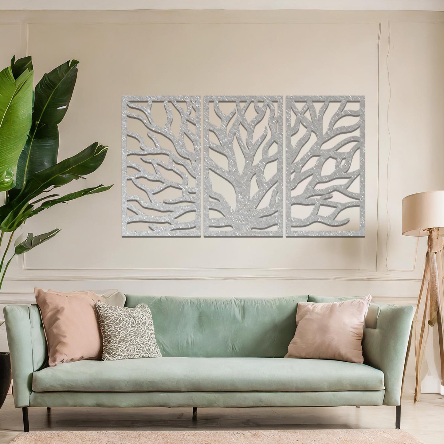 Metal wall art featuring a three-panel design of a tree with intricate branching patterns, crafted with precise laser-cut detailing, placed on a neutral wall within modern decor.